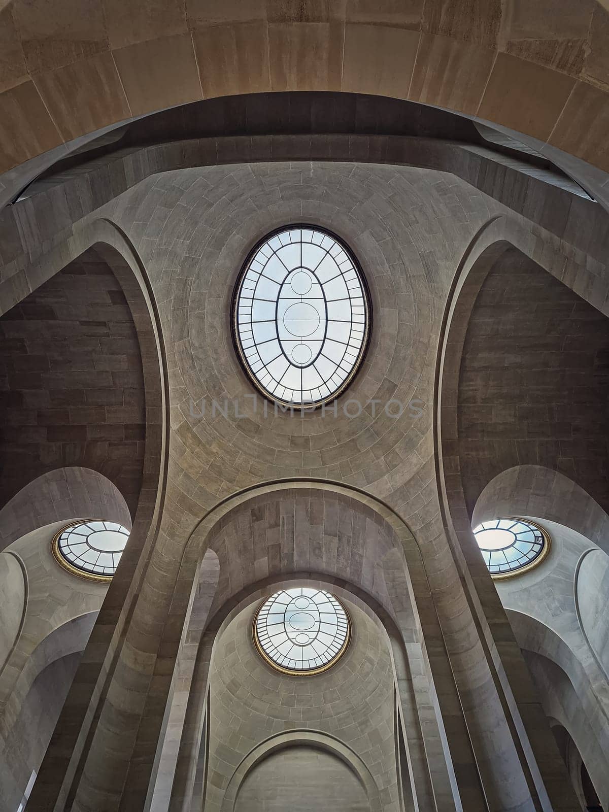 Ceiling architectural details with tall arches and round windows inside Louvre museum hall, Paris, France