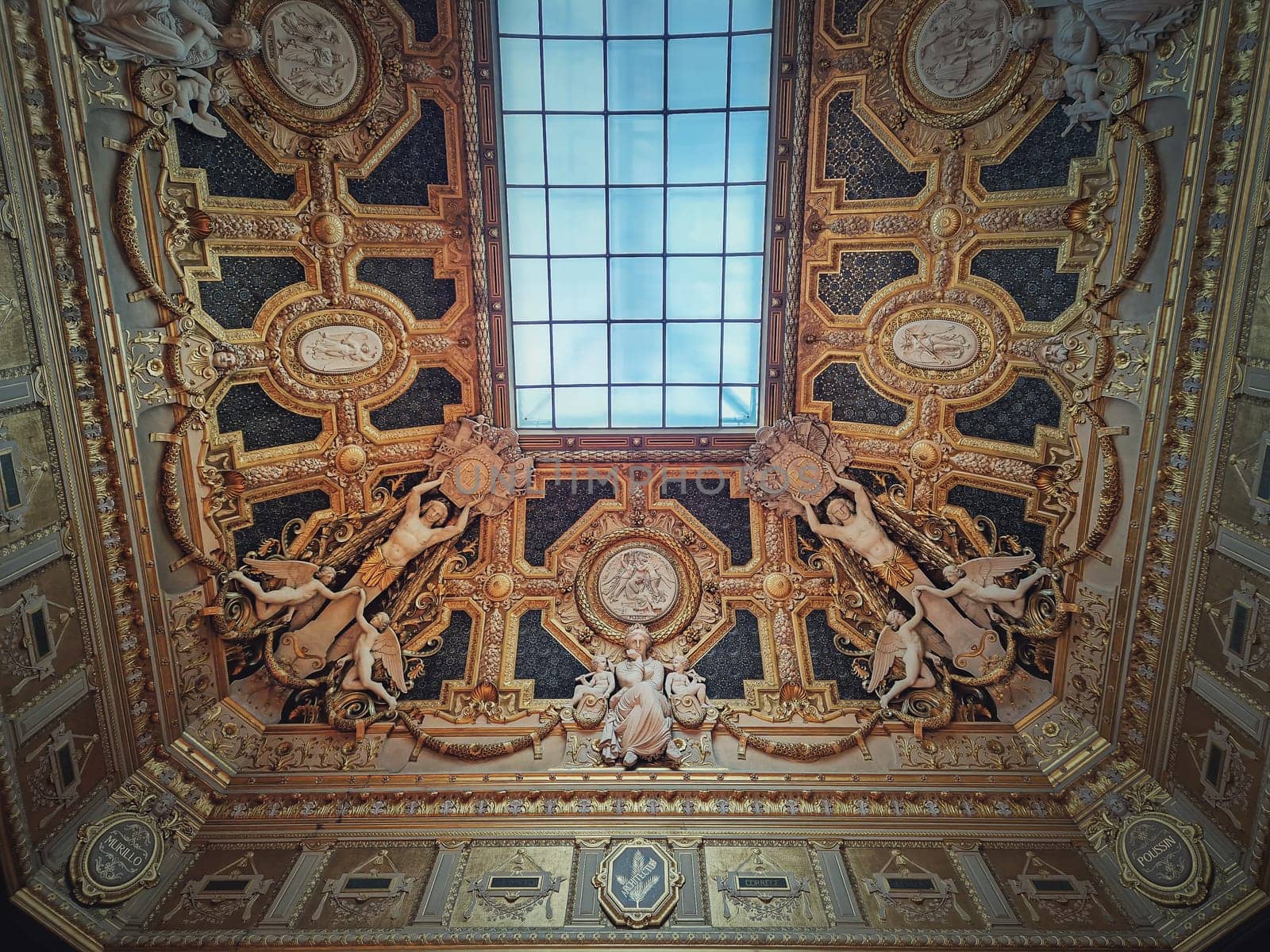 Golden ceiling with architectural details of the Salon Carre inside Louvre museum, Paris, France. Gilded ornaments with sculptures dedicated to Murillo and Poussin by psychoshadow