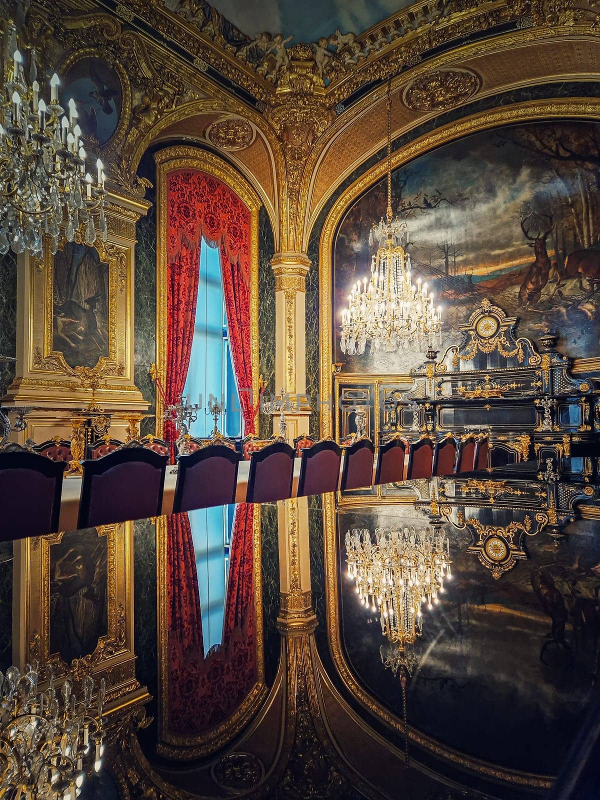 Dining room of Napoleon III at the Louvre Museum. Beautiful decorated royal family apartments, ornate with gold, mural paintings and crystal chandeliers suspended from ceiling by psychoshadow