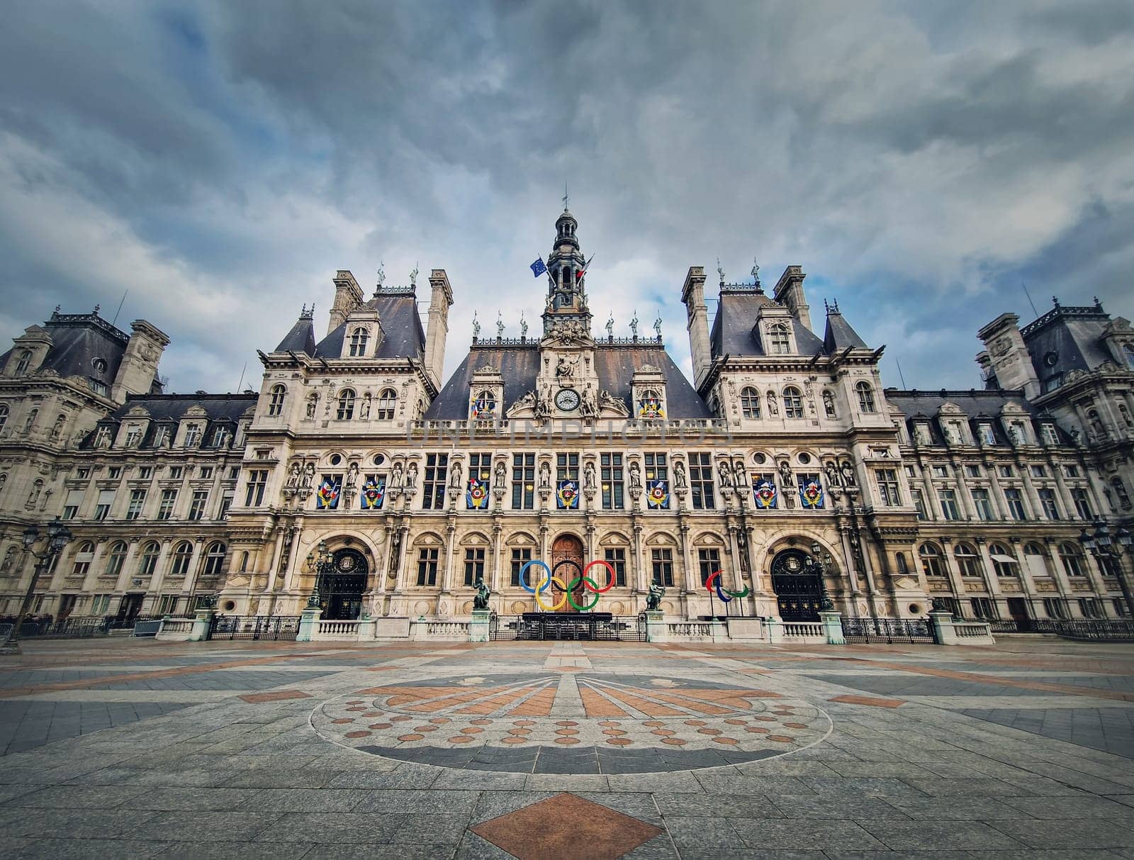 Paris City Hall, France. Outdoors view to the beautiful ornate facade of the historical building and the olympic games rings symbol in front of the central doors by psychoshadow