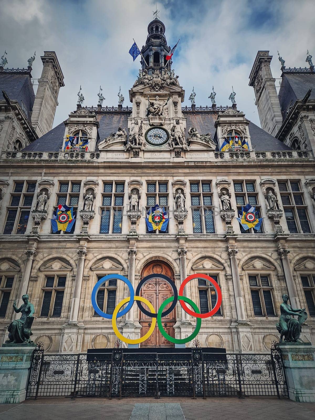 Close up Paris City Hall entrance. Outdoors view to the beautiful ornate facade of the historical building and the olympic games rings symbol in front of the central doors, as France host in 2024