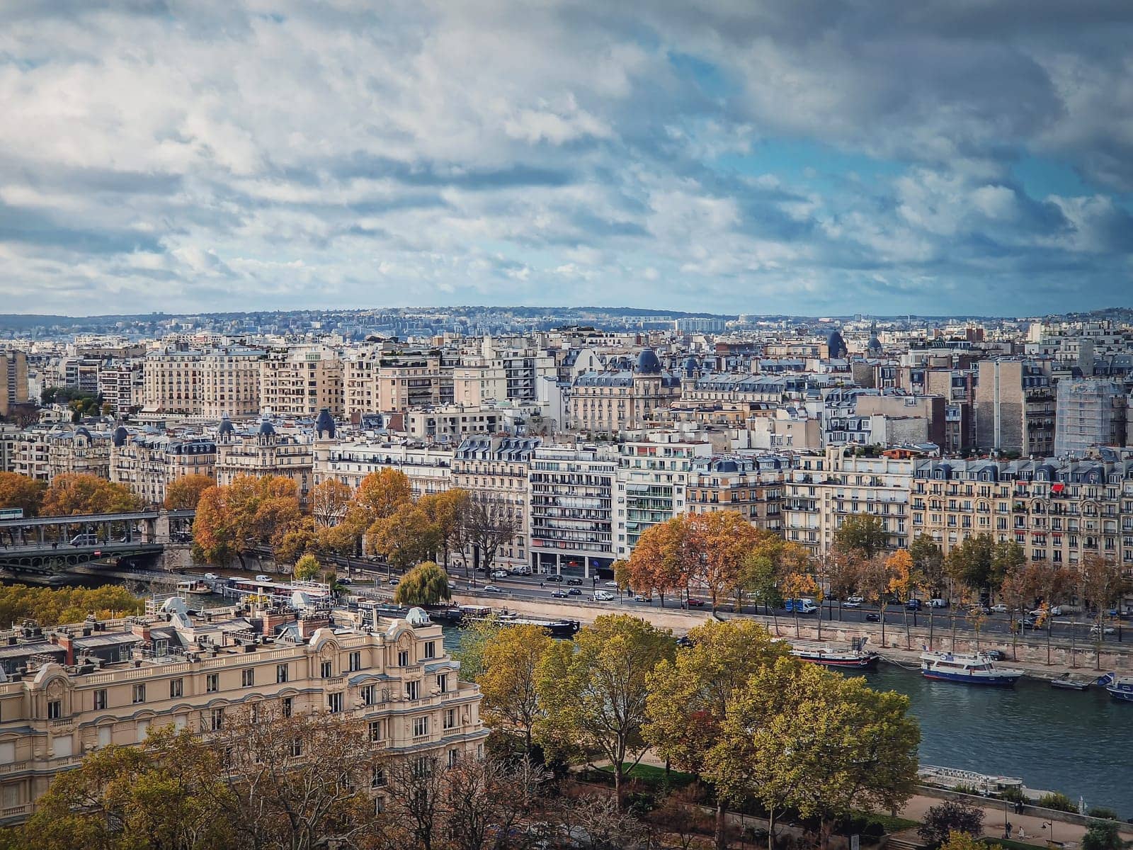 Paris cityscape over the Seine river, view from the Eiffel tower height, France. Fall season scene with colorful yellow trees by psychoshadow