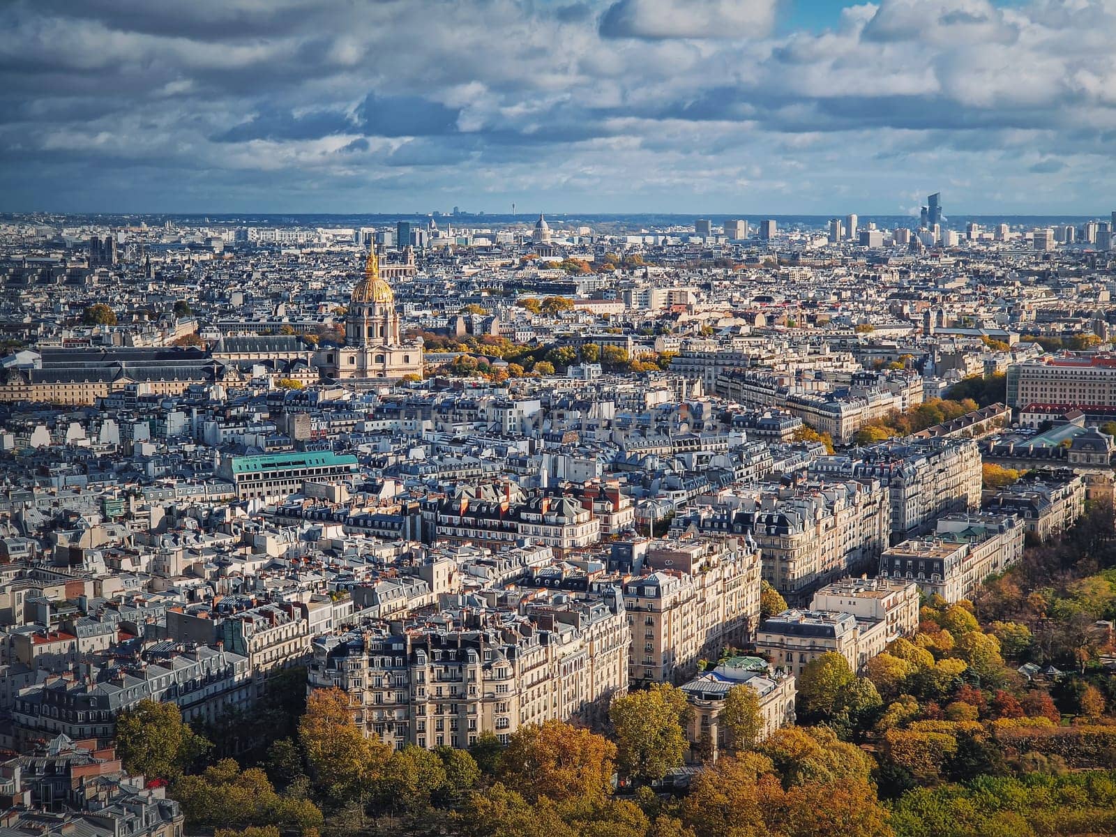 Sightseeing aerial view over the Paris city, France. Les Invalides building with golden dome seen on the horizon. Autumn parisian cityscape by psychoshadow