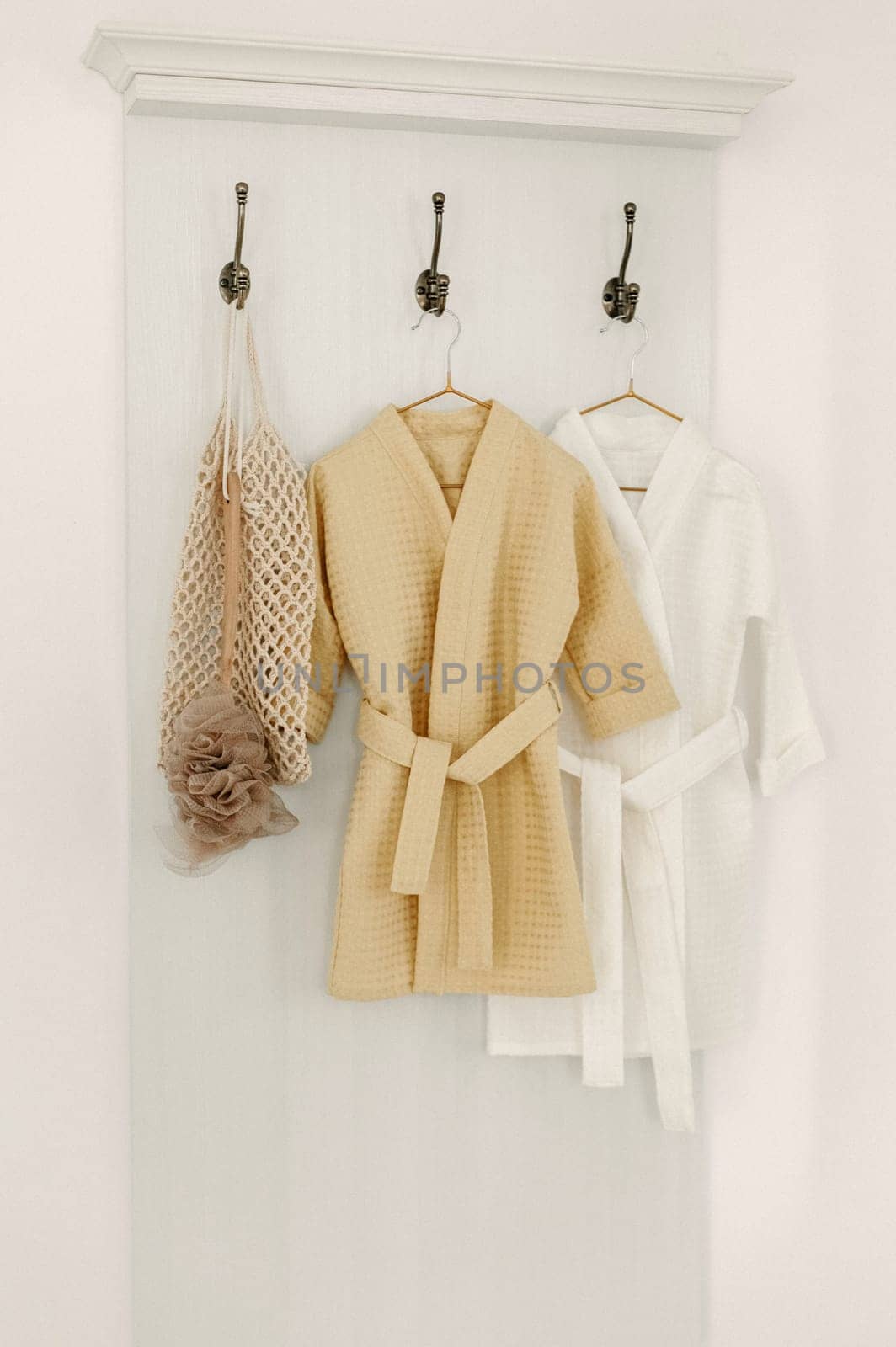 Linen bathrobes hang on a hanger in the bathroom by Sd28DimoN_1976