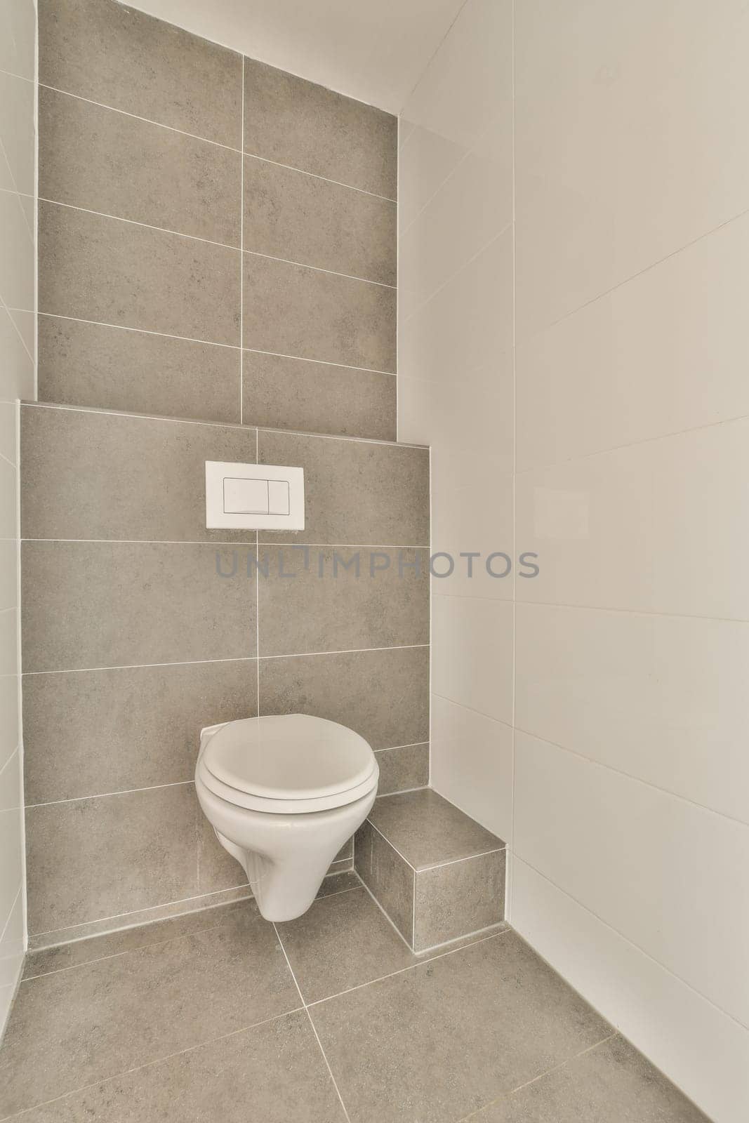 a white toilet in a bathroom with tiled walls by casamedia