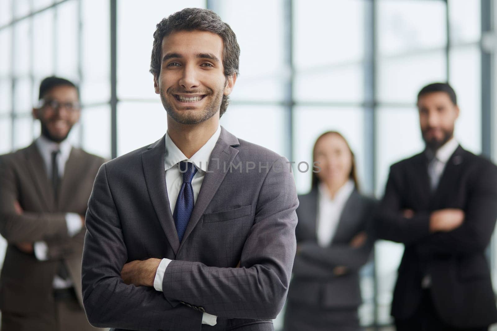 a man poses for the camera with his arms crossed in front of his colleagues by Prosto