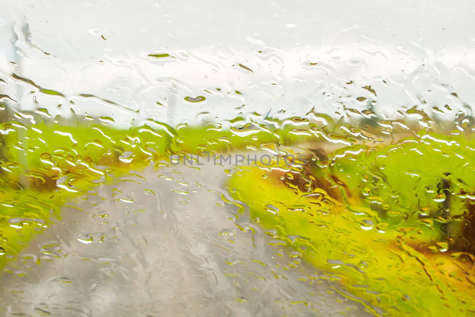 Abstract image of driving on a rural road, through the wet window
