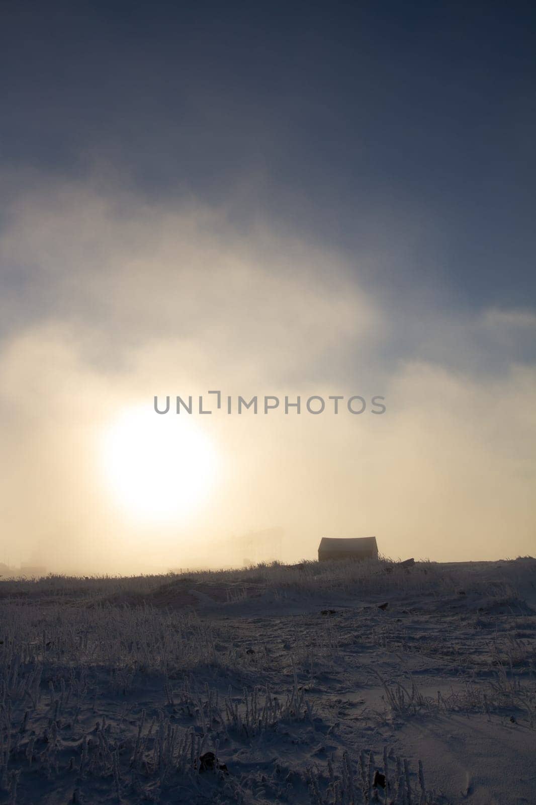 Cabin covered in snow with the sun setting in the background by Granchinho