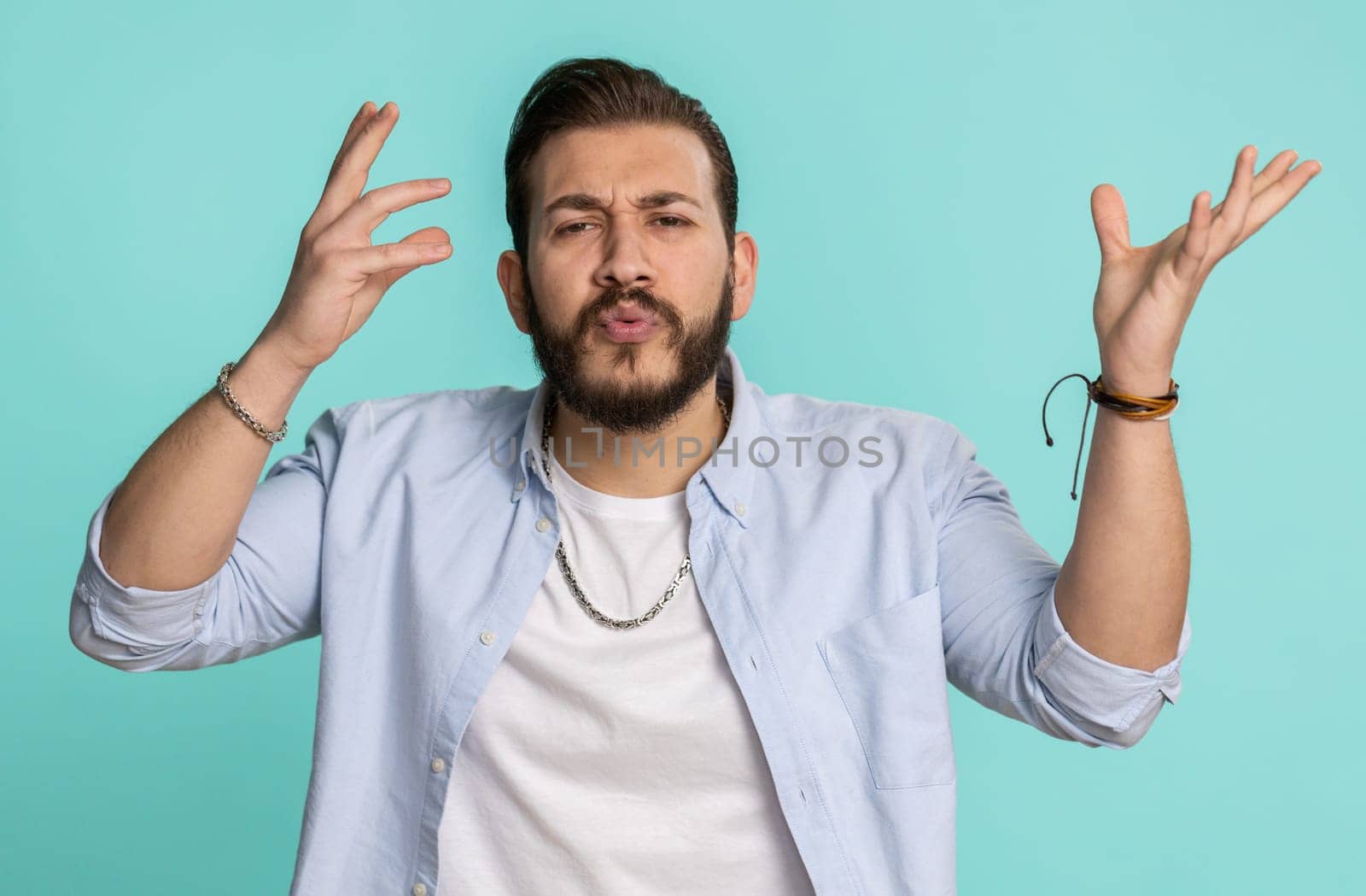 Excited amazed lebanese man touching head and showing explosion, looking worried and shocked celebrating success idea. Looking surprised of win wow arabian guy isolated alone on blue studio background