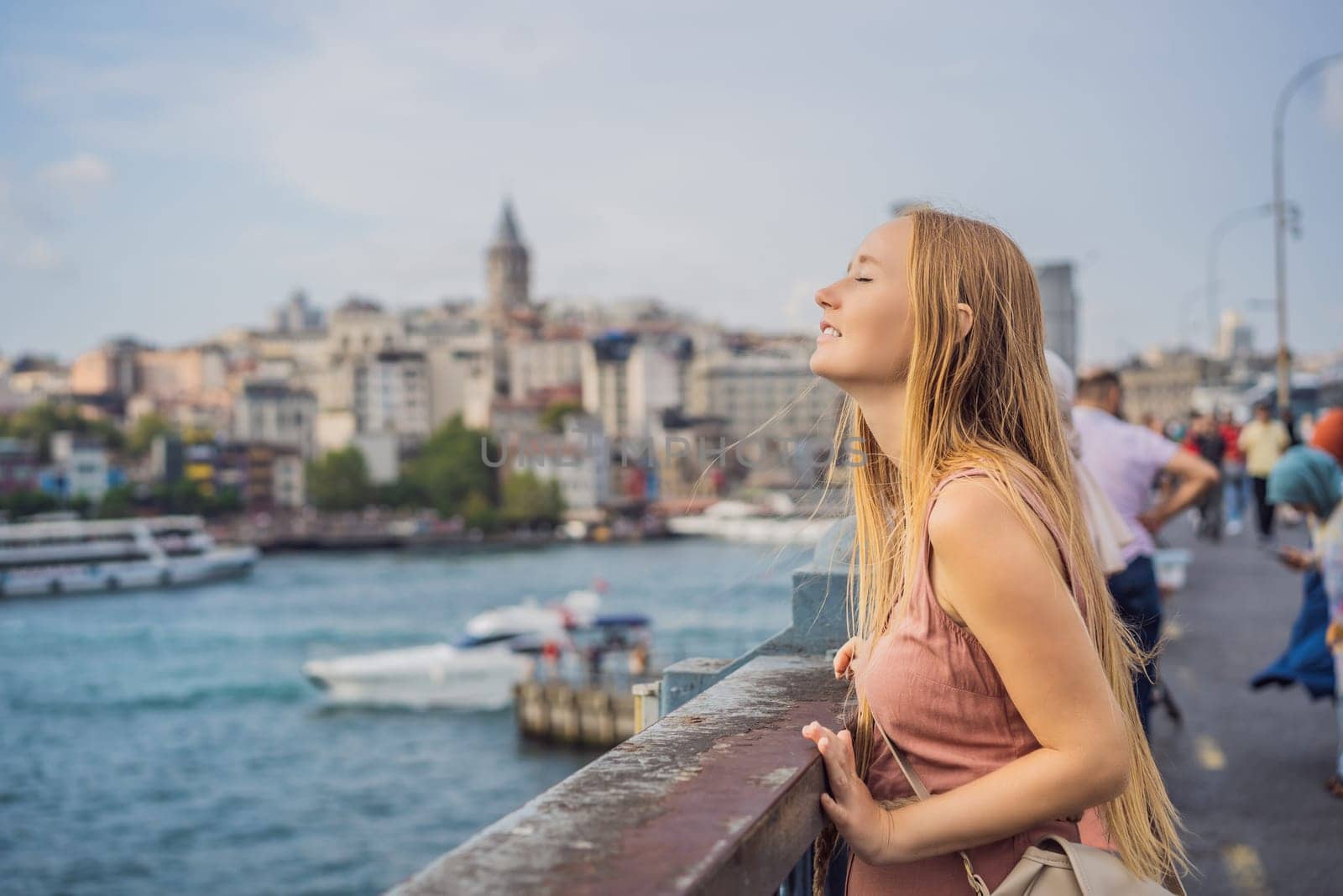 Portrait of beautiful woman tourist with view of Galata tower in Beyoglu, Istanbul, Turkey. Turkiye.