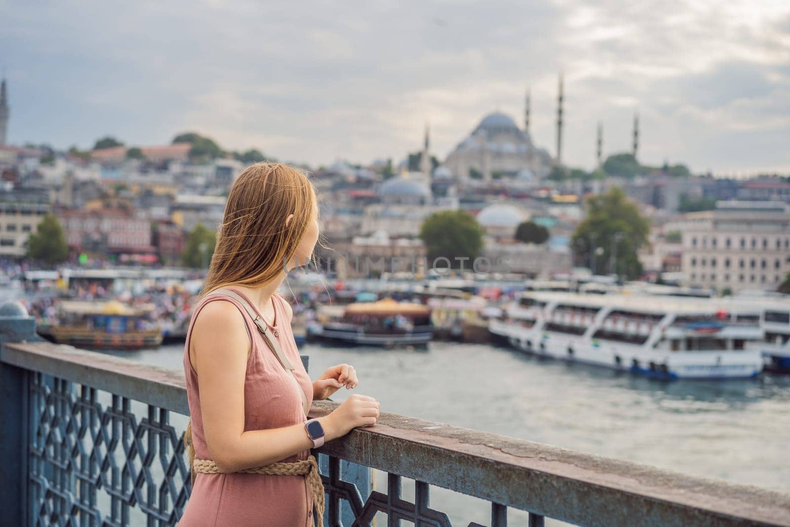 Young tourist woman on Galata bridge, Golden Horn bay, Istanbul. Panorama cityscape of famous tourist destination Bosphorus strait channel. Travel landscape Bosporus, Turkey, Europe and Asia.