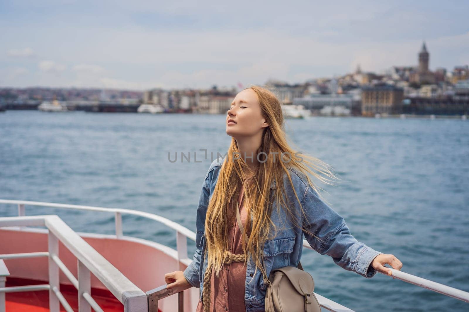 Happy woman enjoying the sea from ferry boat crossing Bosphorus in Istanbul. Summer trip to Istanbul.