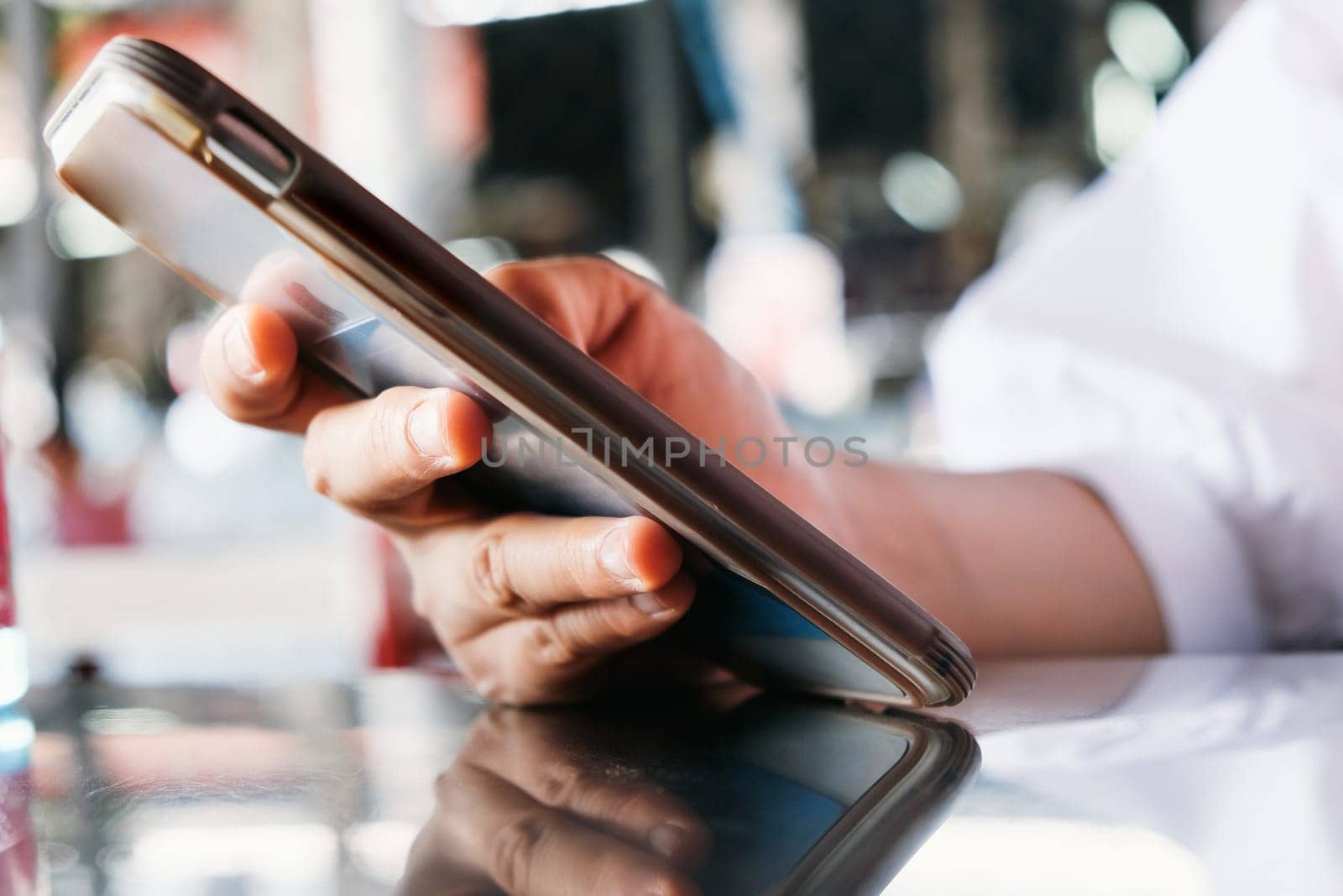 Close up shot of a woman using a mobile phone in a cafe by ponsulak