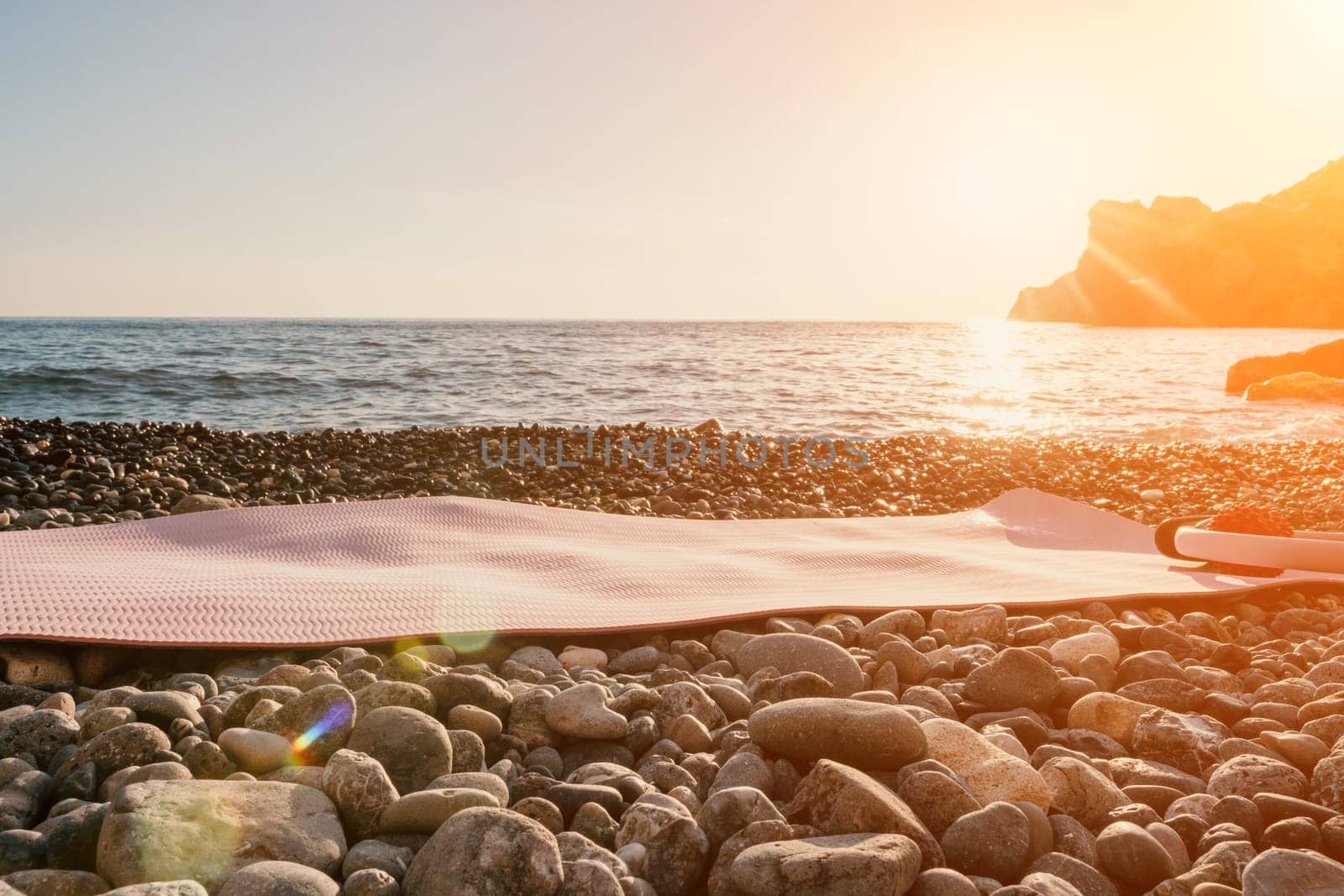 Pilates magic ring and rubber ball on yoga mat near sea. Female fitness yoga concept. Healthy lifestyle harmony and meditation. by panophotograph