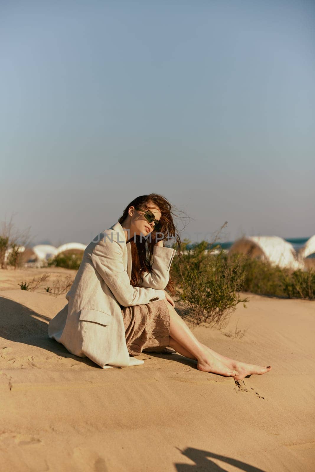a woman on the beach sits in a stylish jacket during her vacation. High quality photo