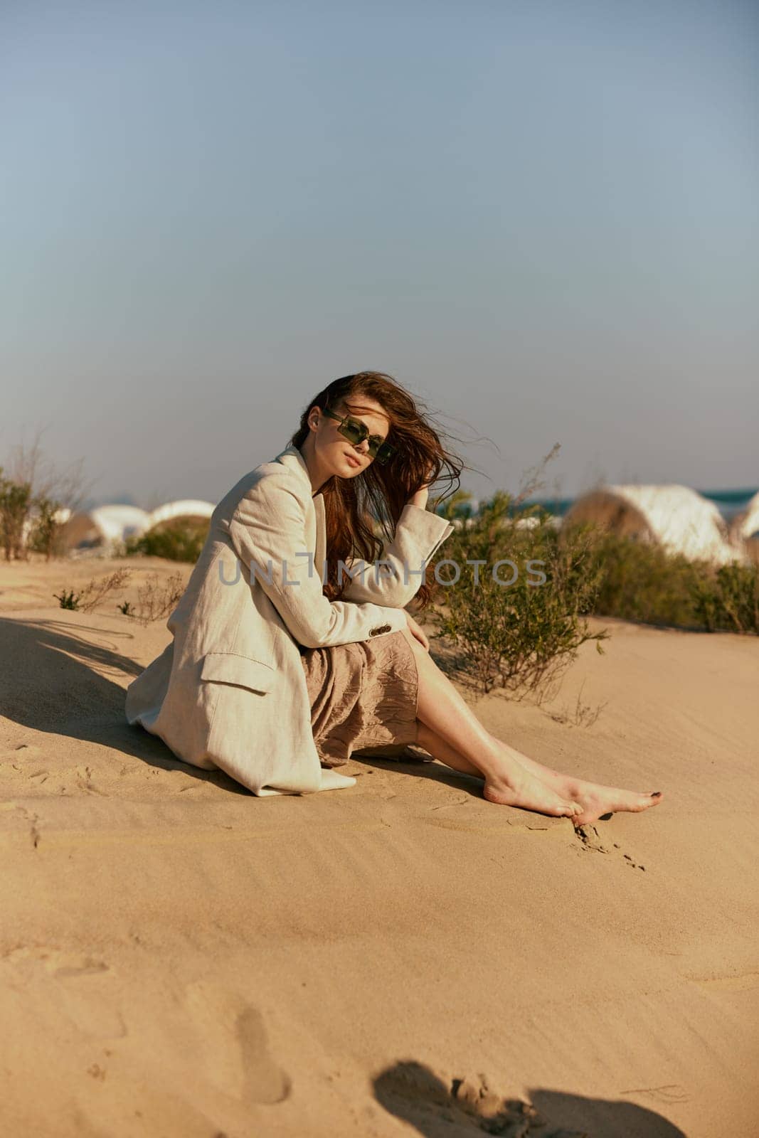 a woman on the beach sits in a stylish jacket during her vacation. High quality photo