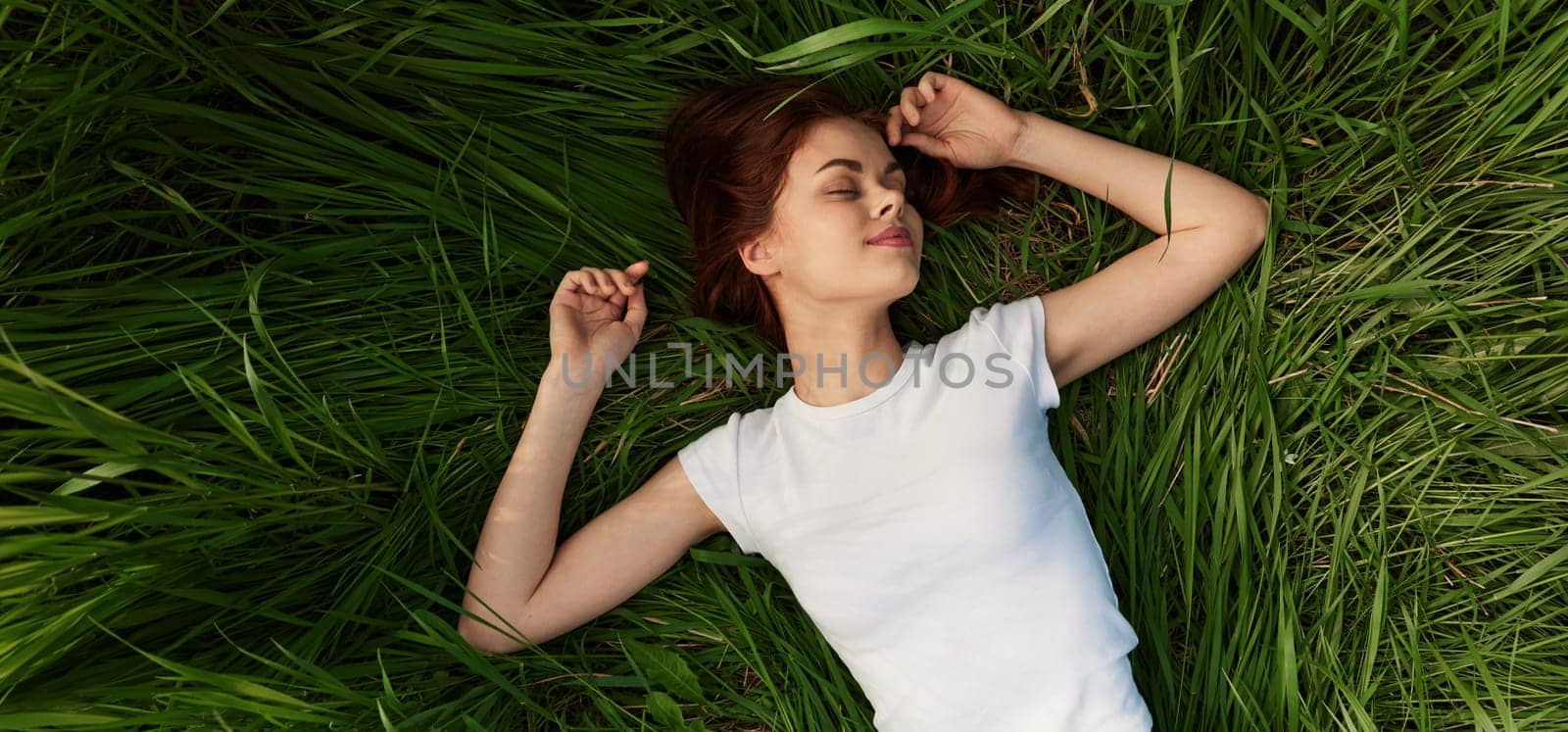 happy woman lies in green grass field. High quality photo