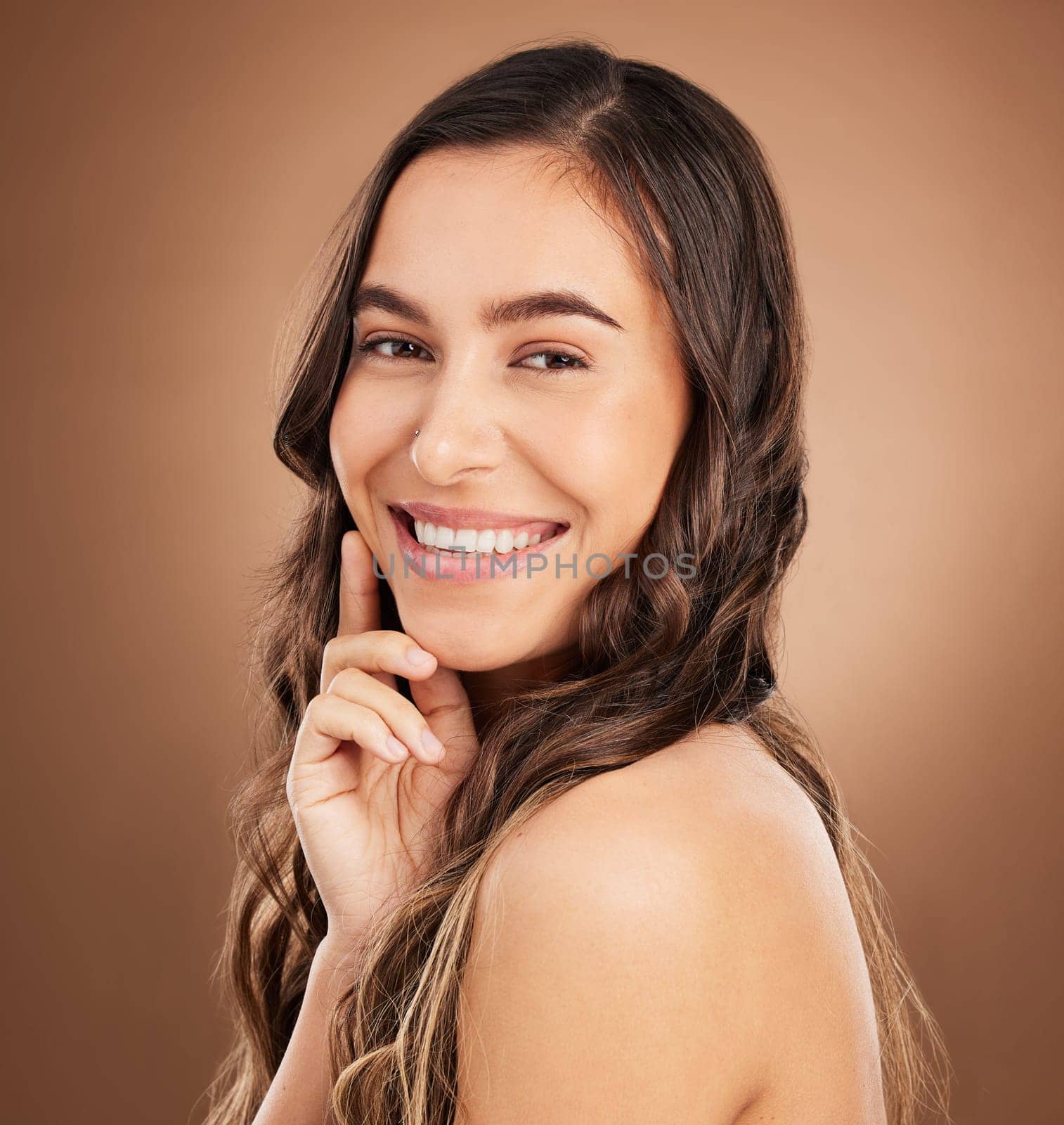 Portrait, beauty and woman in studio for hair, treatment and cosmetics against a brown background. Haircare, face and girl smile for natural, curly or wavy, texture or keratin, textures and confident.