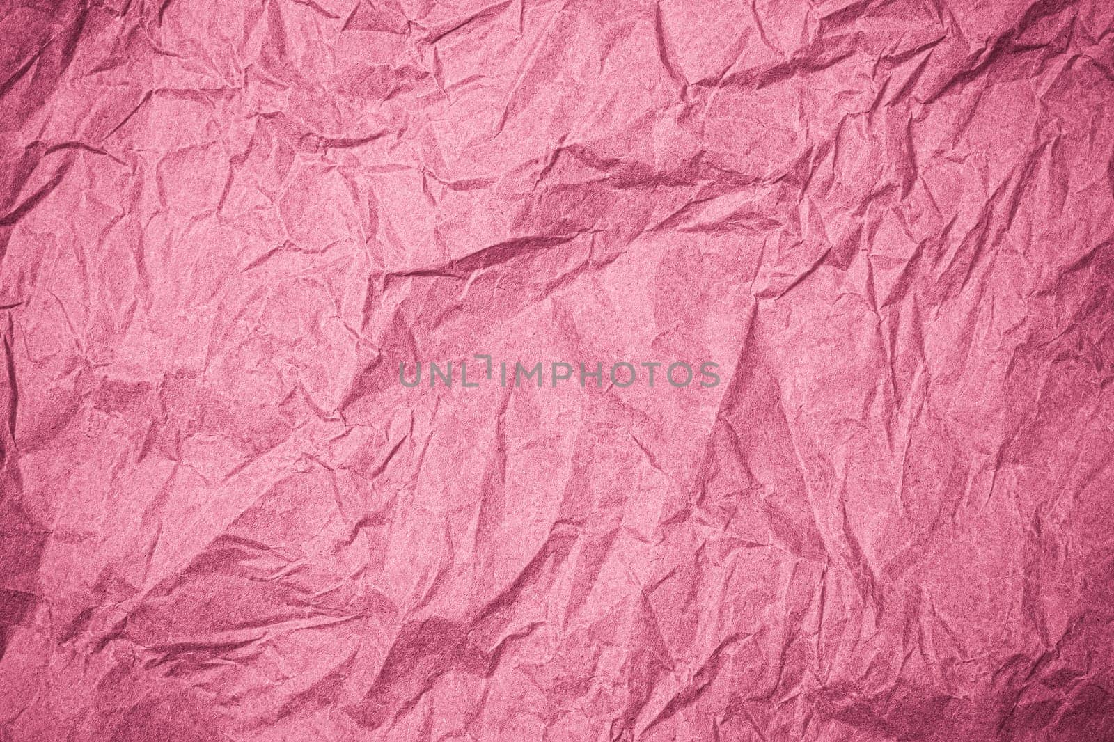 Top view of wrinkled textured paper. Pink crumpled paper texture background. Wrinkled, abstract paper background