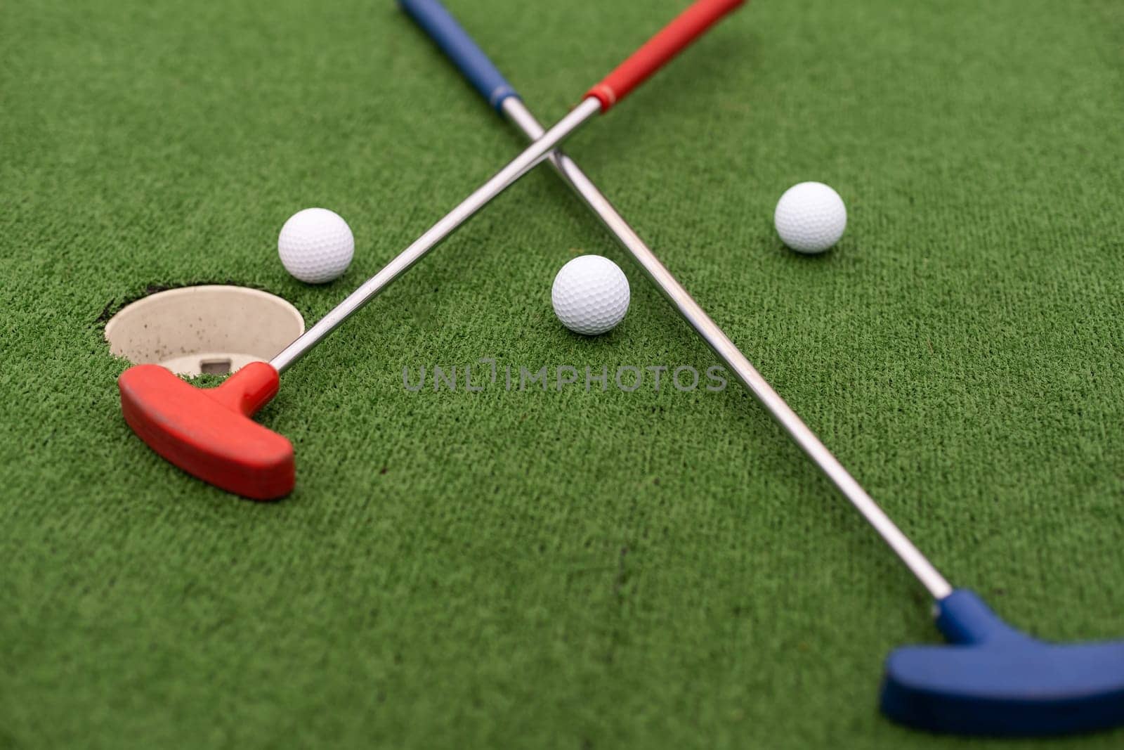 Mini golf close-up, colorful golf putters, balls by Andelov13