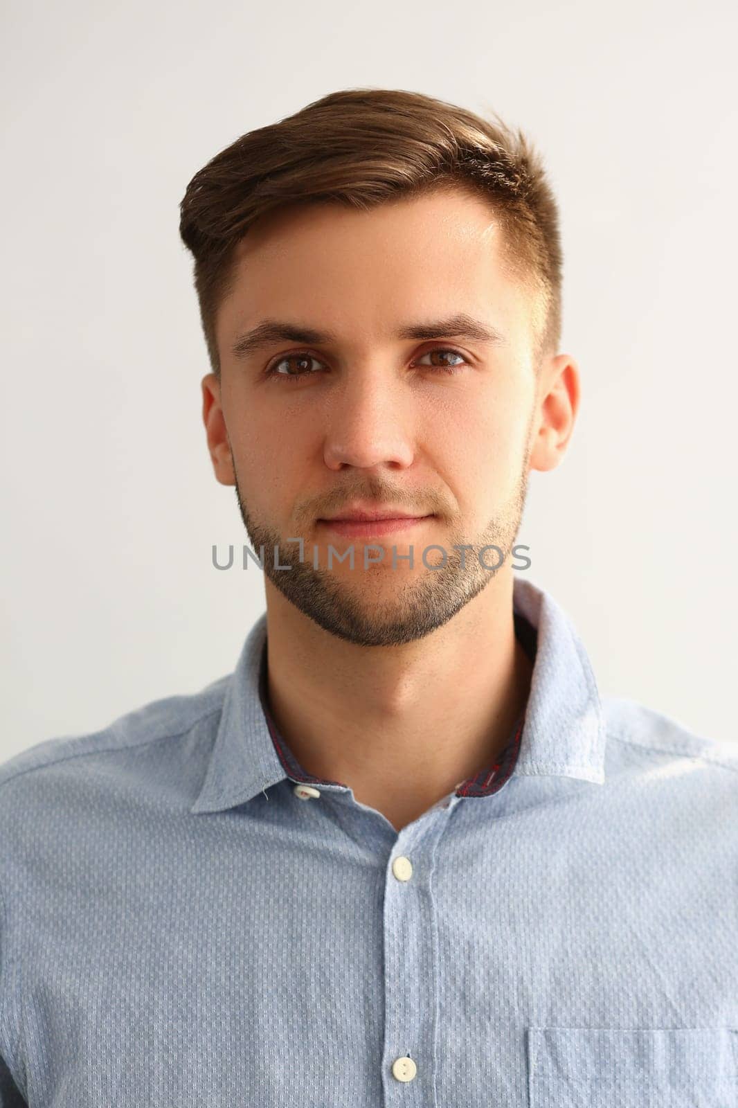 Portrait of handsome young man in blue shirt. Serious smart successful leader man