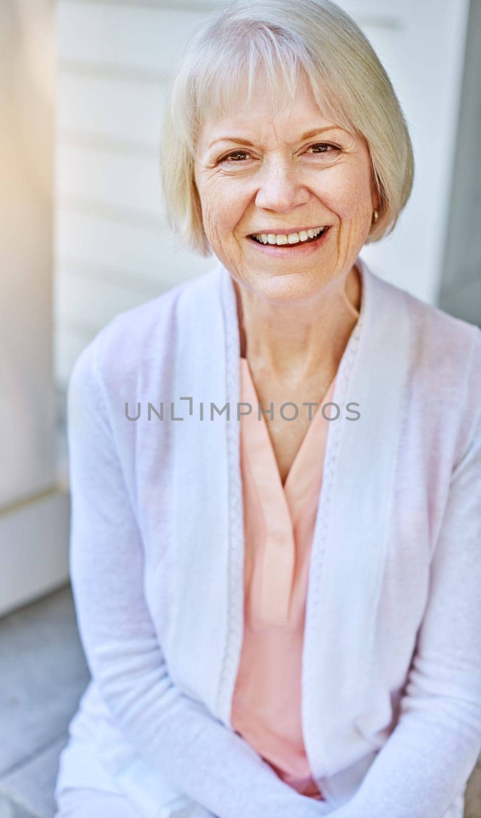 Im wearing my summer smile. Cropped portrait of a senior woman sitting on her porch during the summer. by YuriArcurs