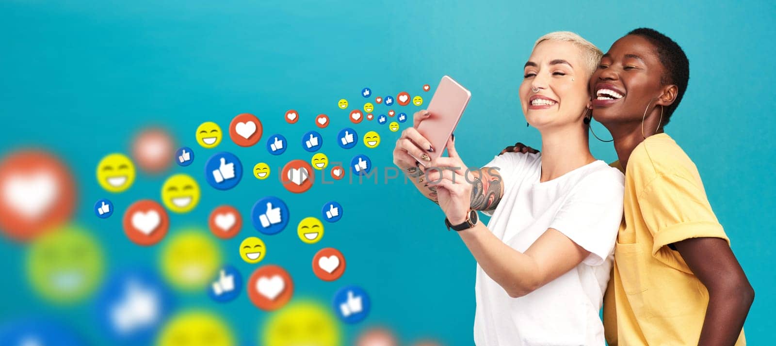 Women, social media icons or friends take a selfie for content or online post on blue background. Love emojis, diversity or happy girls take pictures together on mobile app website or digital network.