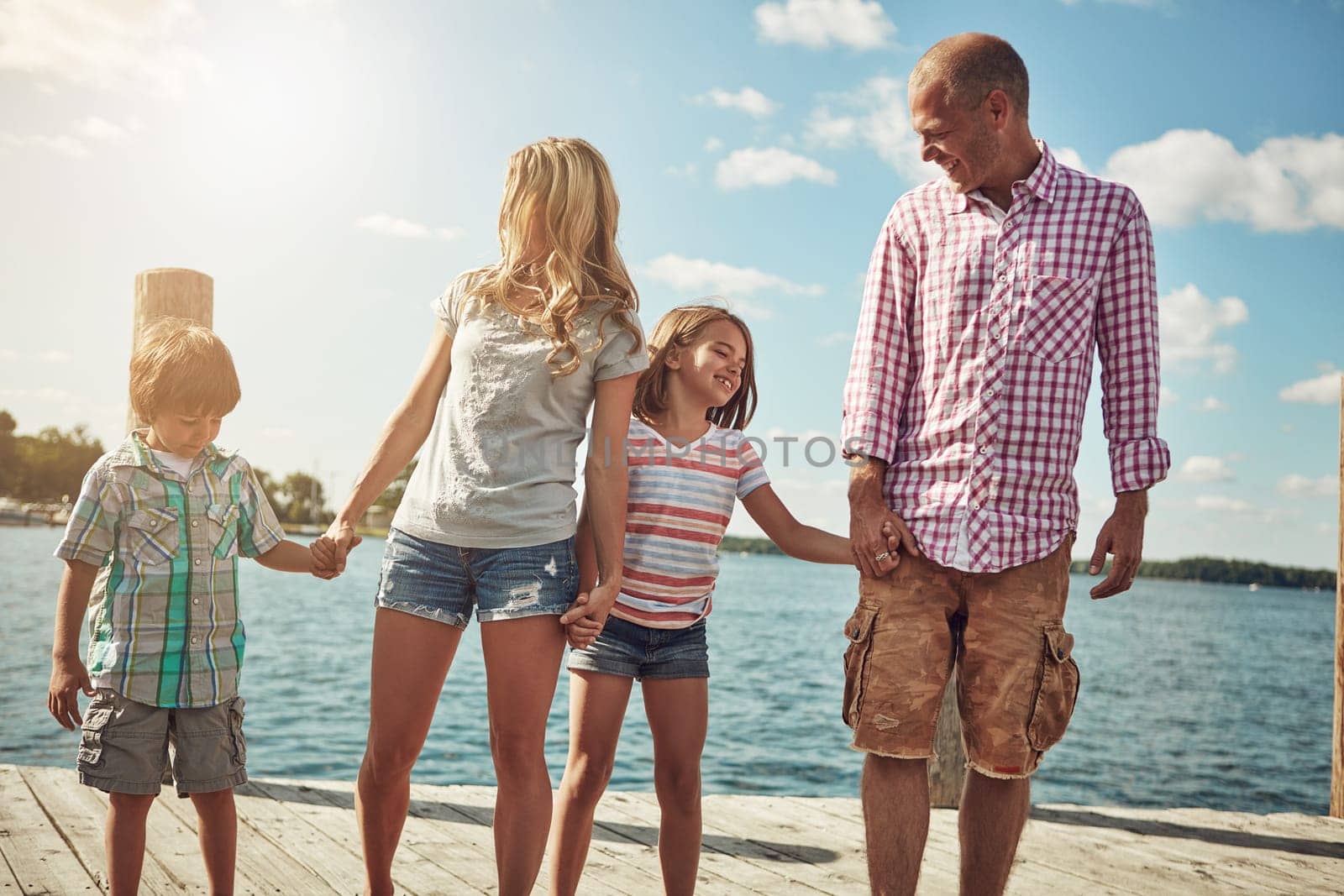 Family is a gift that lasts forever. a young family on a pier while out by the lake