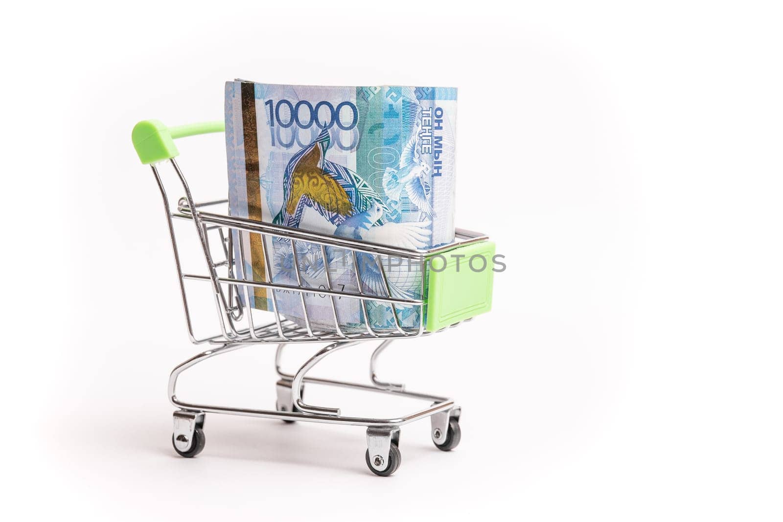 10000 banknotes of Kazakhstani tenge in a shopping cart isolated on a white background.