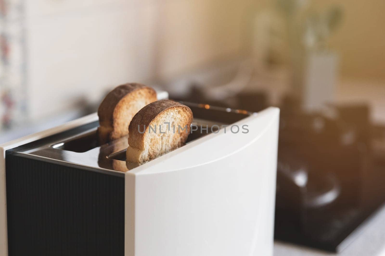 2 white toasted slices of bread in a white toaster in home kitchen, selective soft focus.