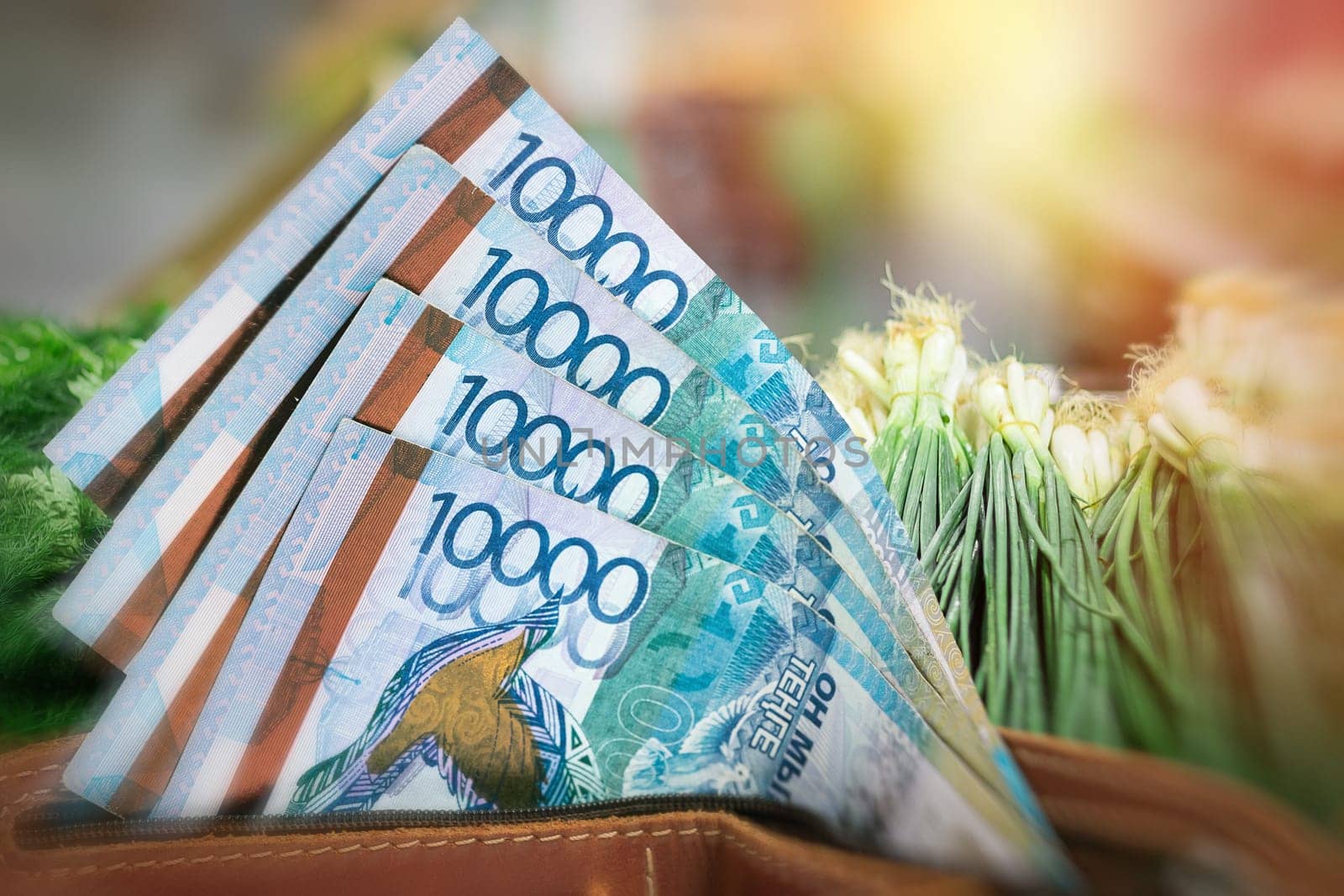 Rising prices for vegetables and agricultural products in Kazakhstan. Tenge in a wallet against the background of a counter with greenery.