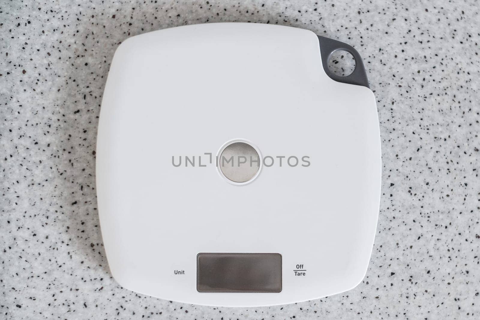 Digital kitchen scale on a kitchen table. Top view on electronic scales for measurement the food weight.