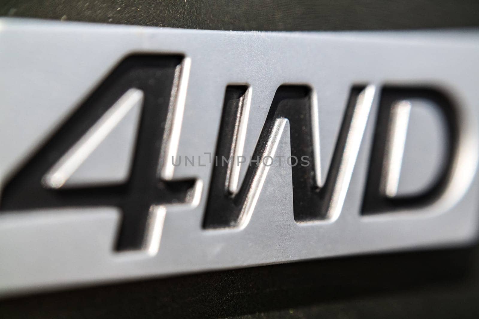 The inscription 4WD close-up on the nameplate of an SUV, selective soft focus.
