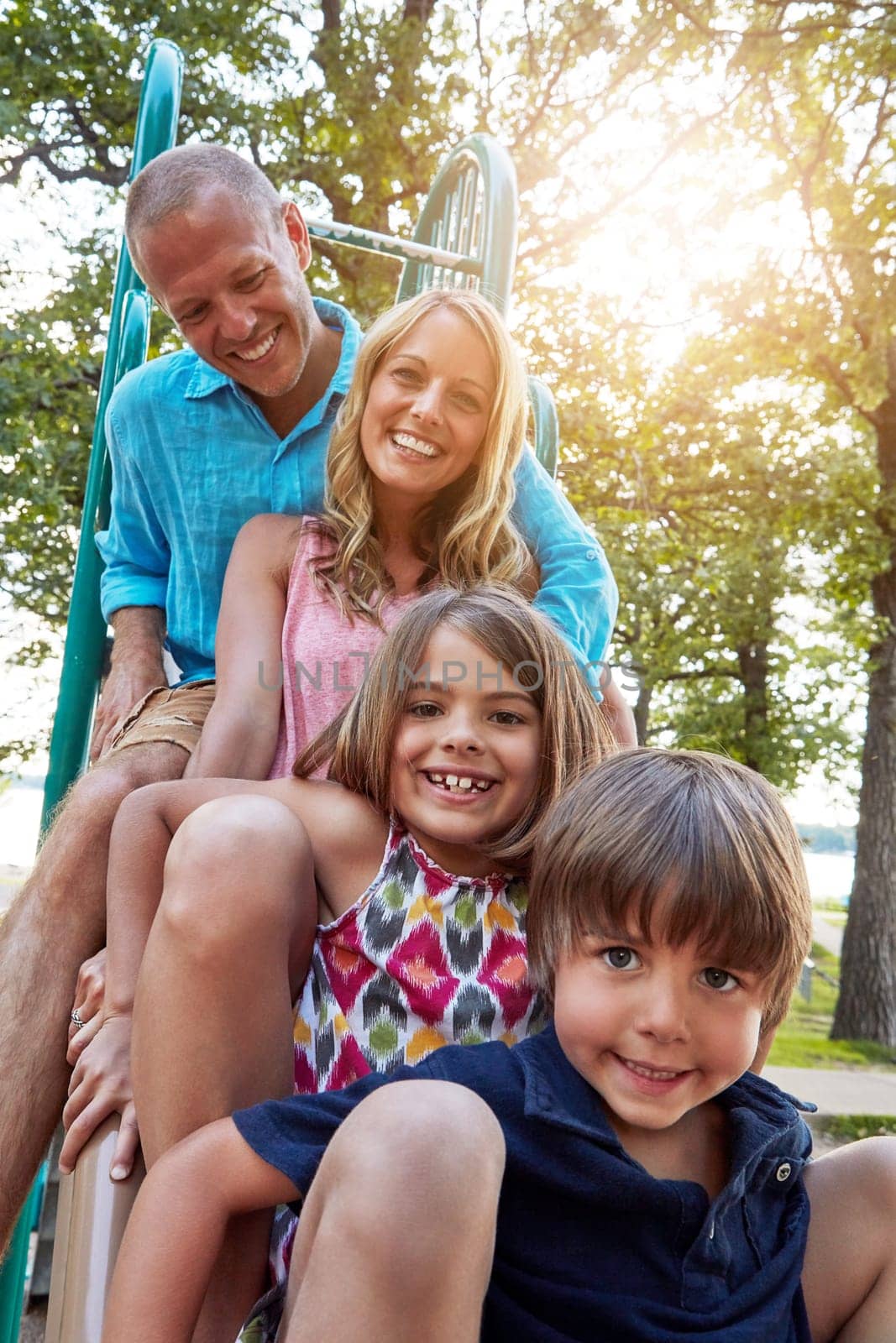 Together through any ups and downs. a young family playing in a playground outdoors