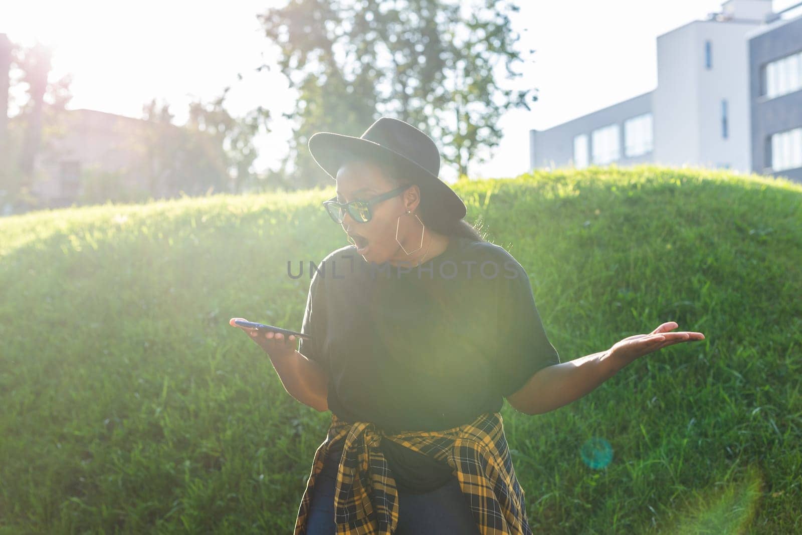 African american woman browsing social networks in the city - millennial generation and urban concept by Satura86