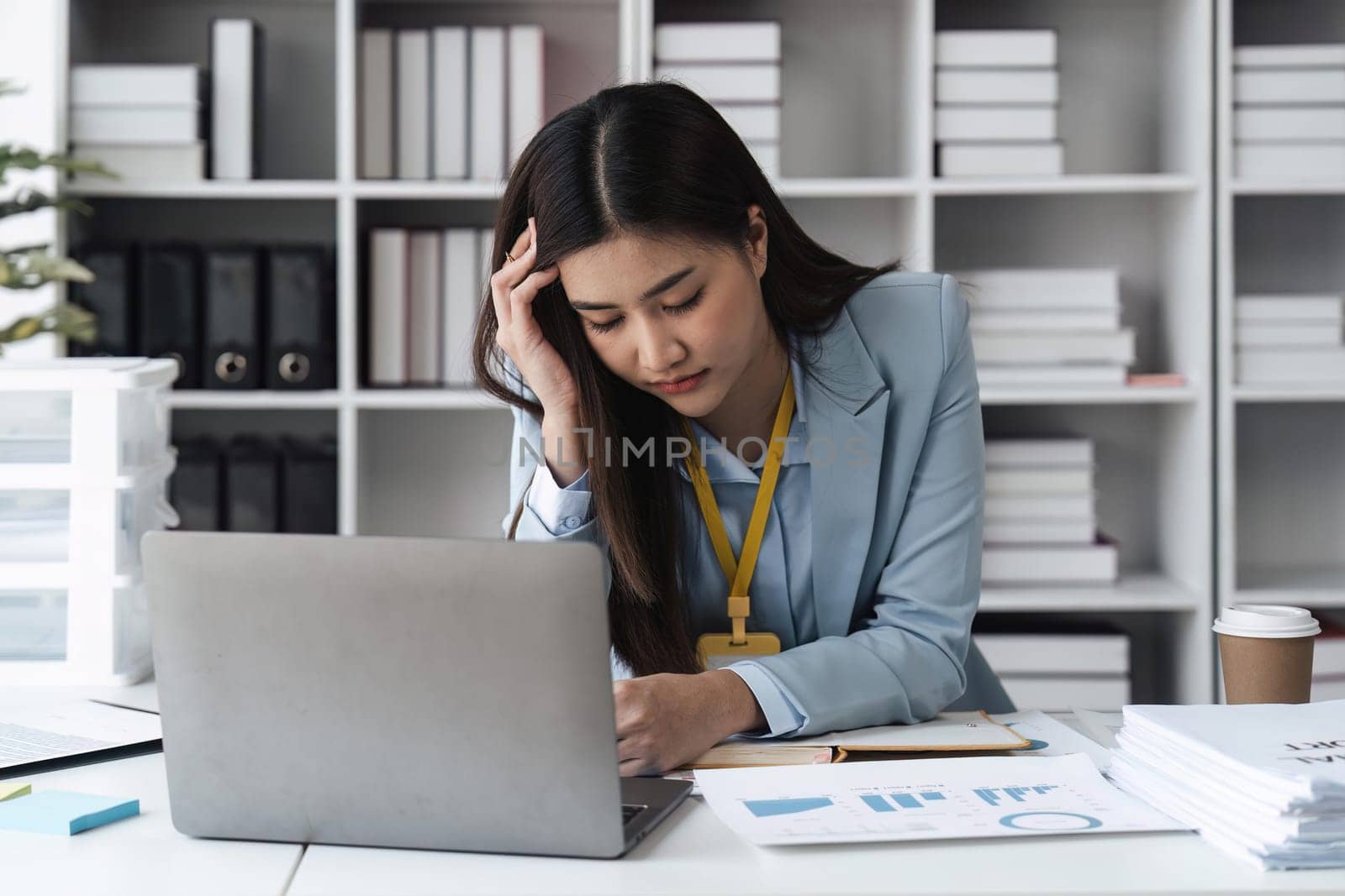 Asian businesswoman are stressed and tired from work sitting at desk in the office, feeling sick at work, stress from work. by nateemee