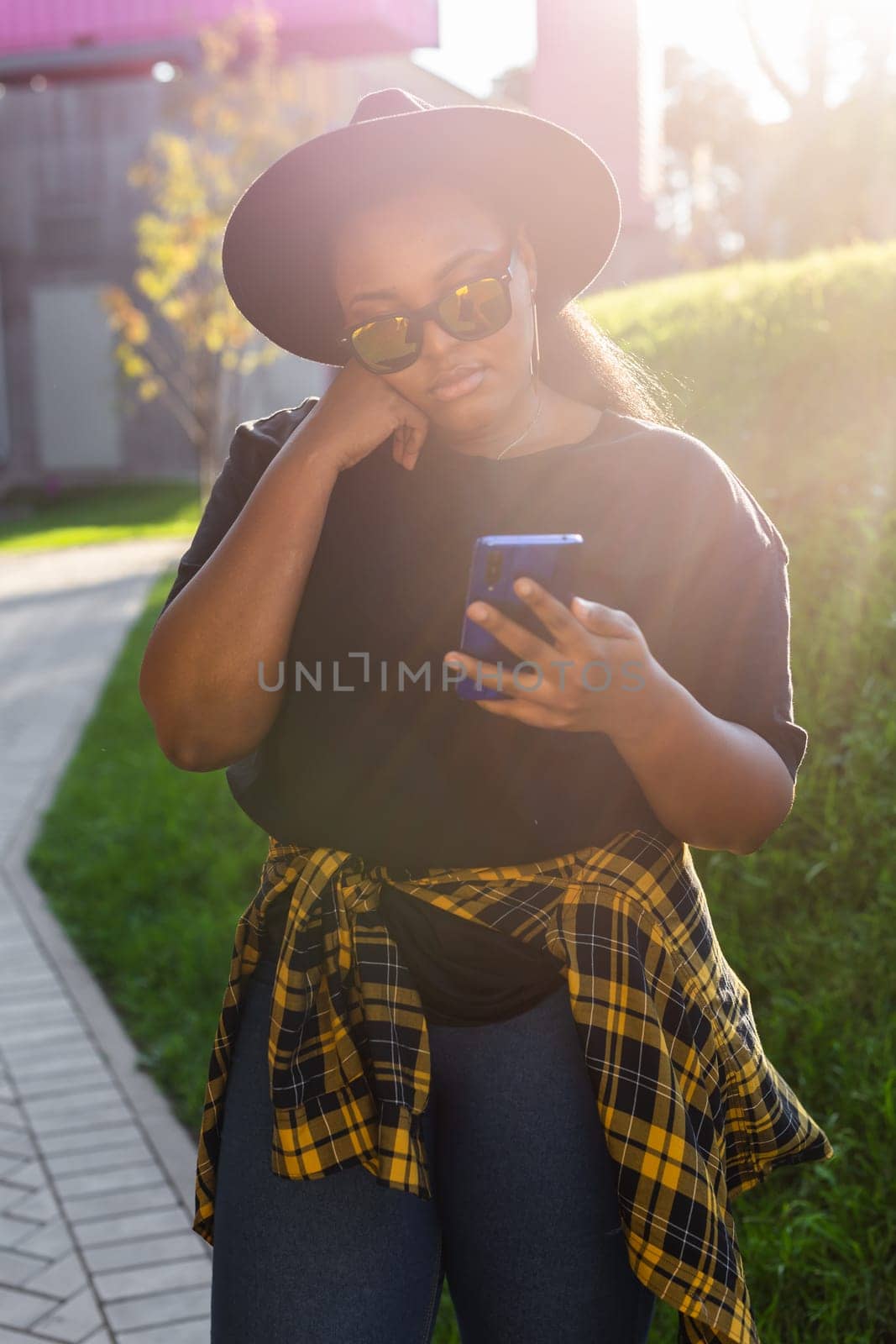 African american woman browsing social networks in the city - millennial generation and urban concept by Satura86