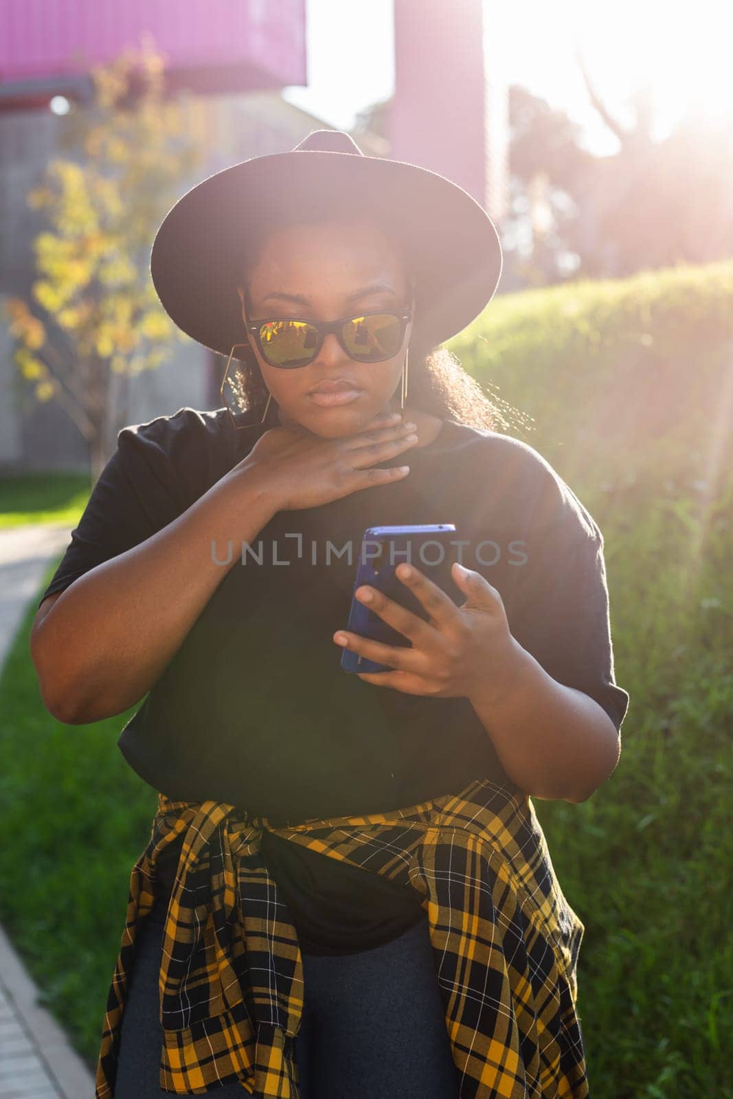 African american woman browsing social networks in the city - millennial generation and urban concept by Satura86