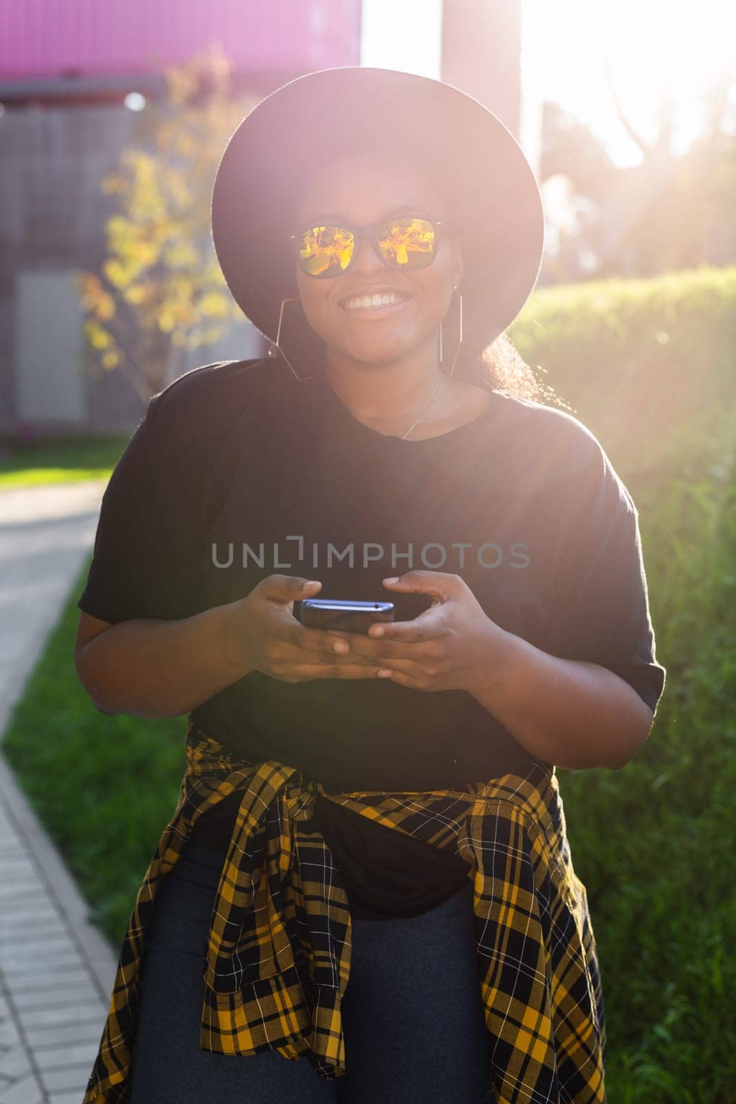 African american woman browsing social networks in the city - millennial generation and urban concept by Satura86