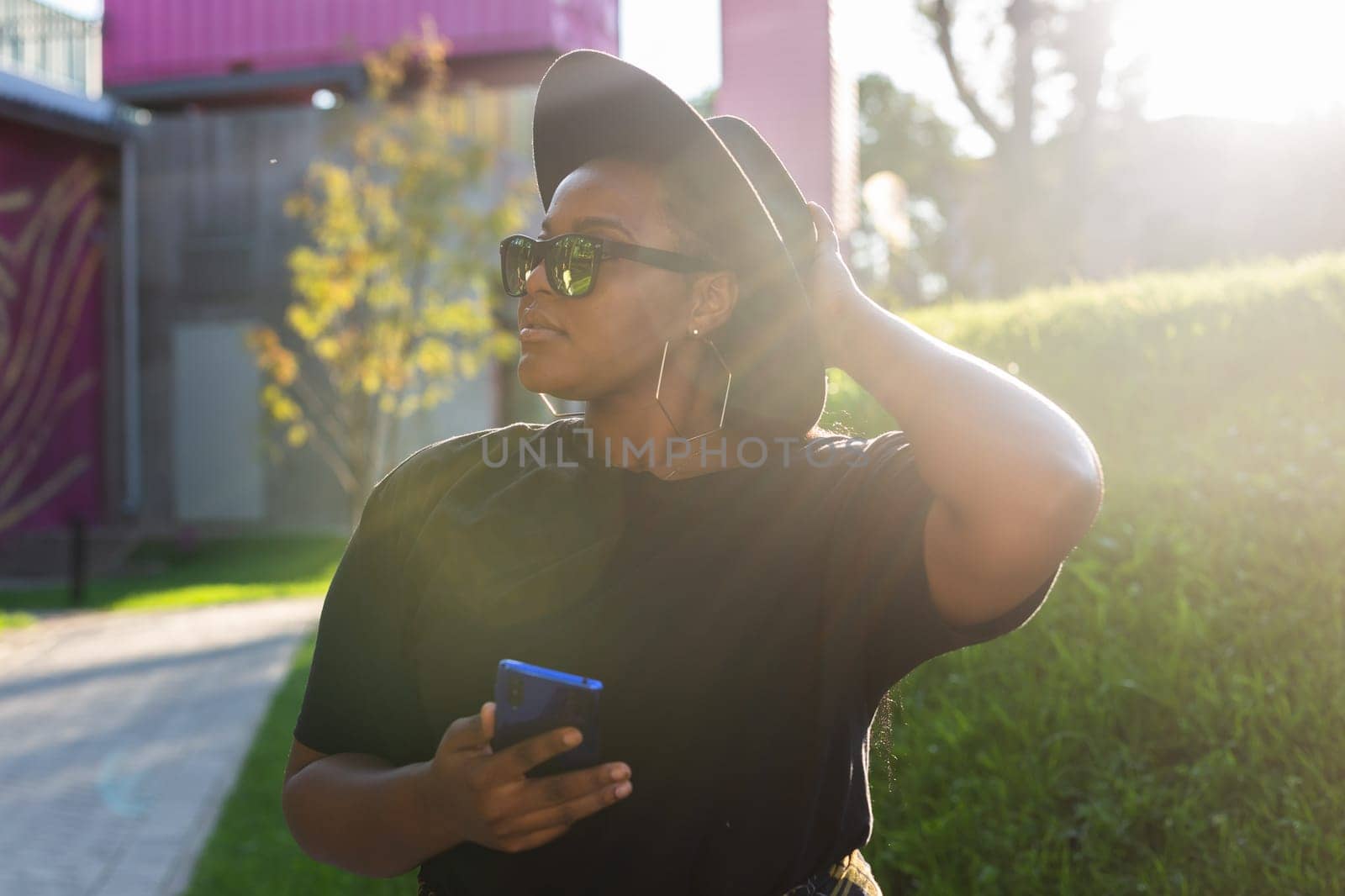 African american woman browsing social networks in the city - millennial generation and urban concept by Satura86