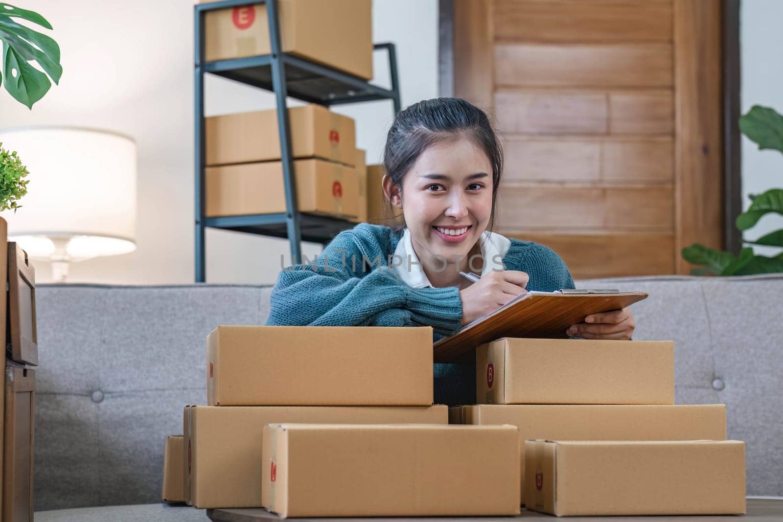 Portrait young attractive asian female owner startup business work happy with box at home prepare parcel delivery in sme supply chain, start up small business concept...