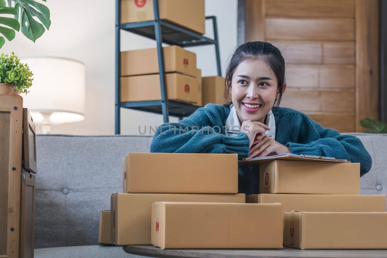 Portrait young attractive asian female owner startup business work happy with box at home prepare parcel delivery in sme supply chain, start up small business concept...