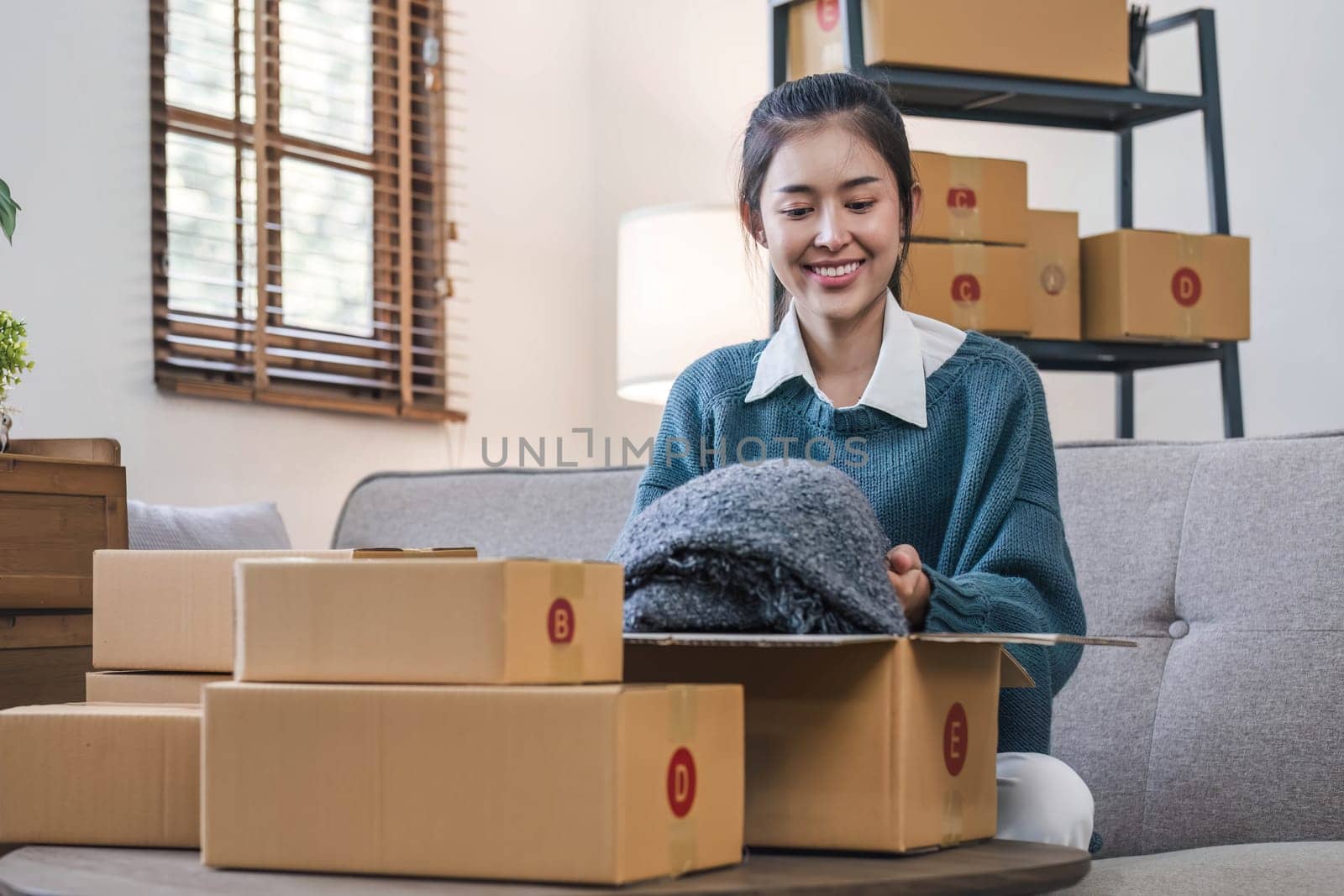 Portrait young attractive asian female owner startup business work happy with box at home prepare parcel delivery in sme supply chain, start up small business concept. by wichayada