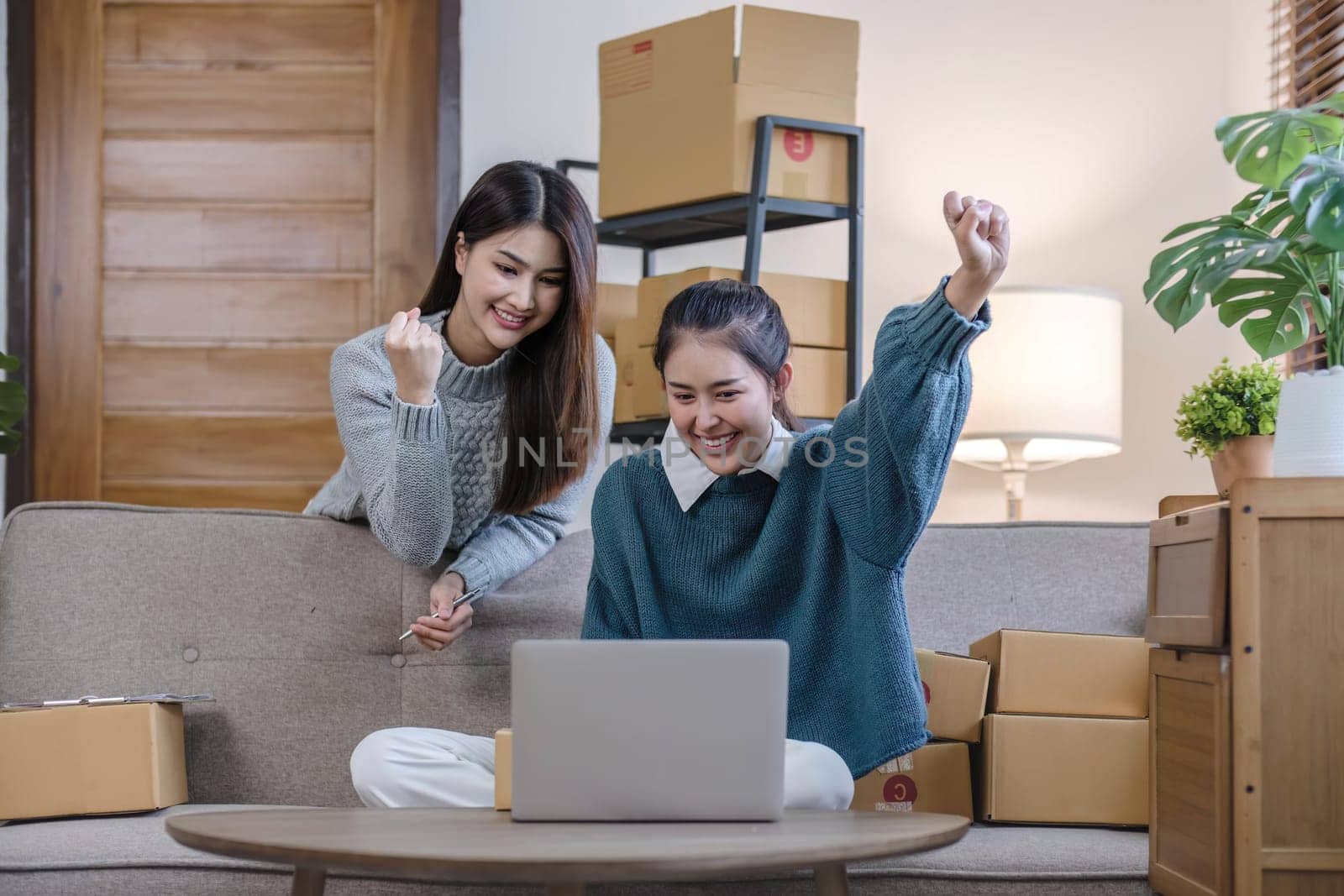Two Asian Young business woman on sofa at home. startup sme small business entrepreneur SME distribution warehouse with parcel mail box. SME Online marketing and product packaging and delivery service by wichayada