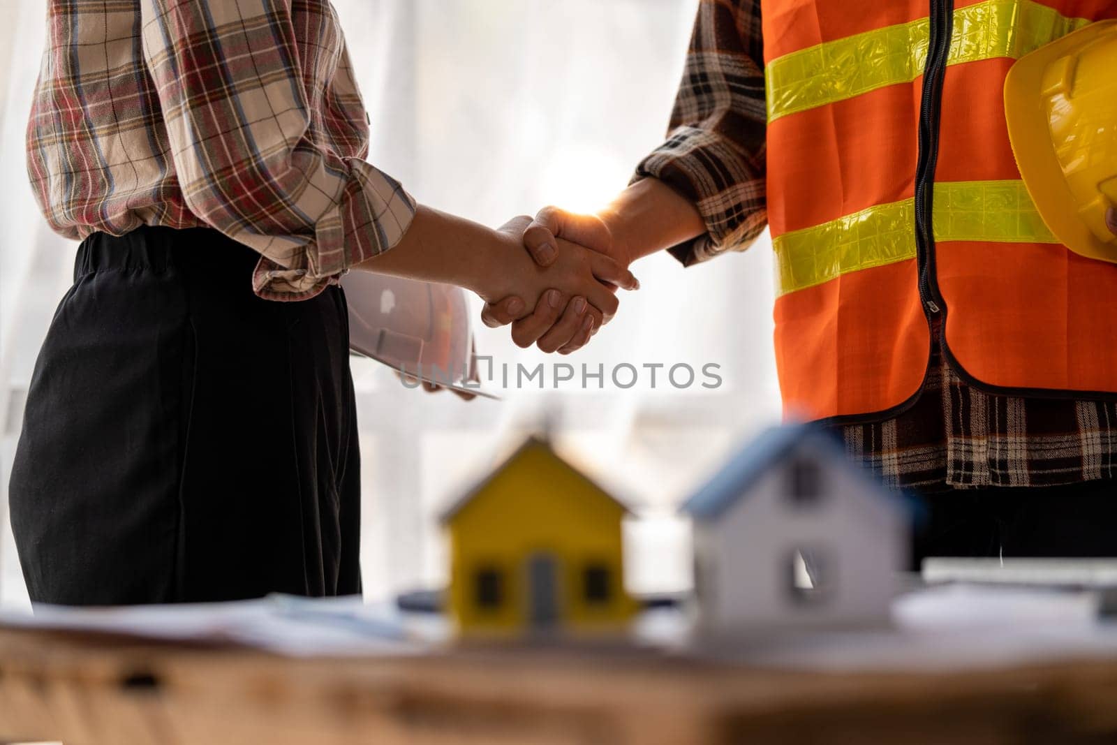 successful team engineers and business partner shaking hand, engineer and architecture shaking hand after finish an agreement, professional engineer plan to build a house. High quality photo