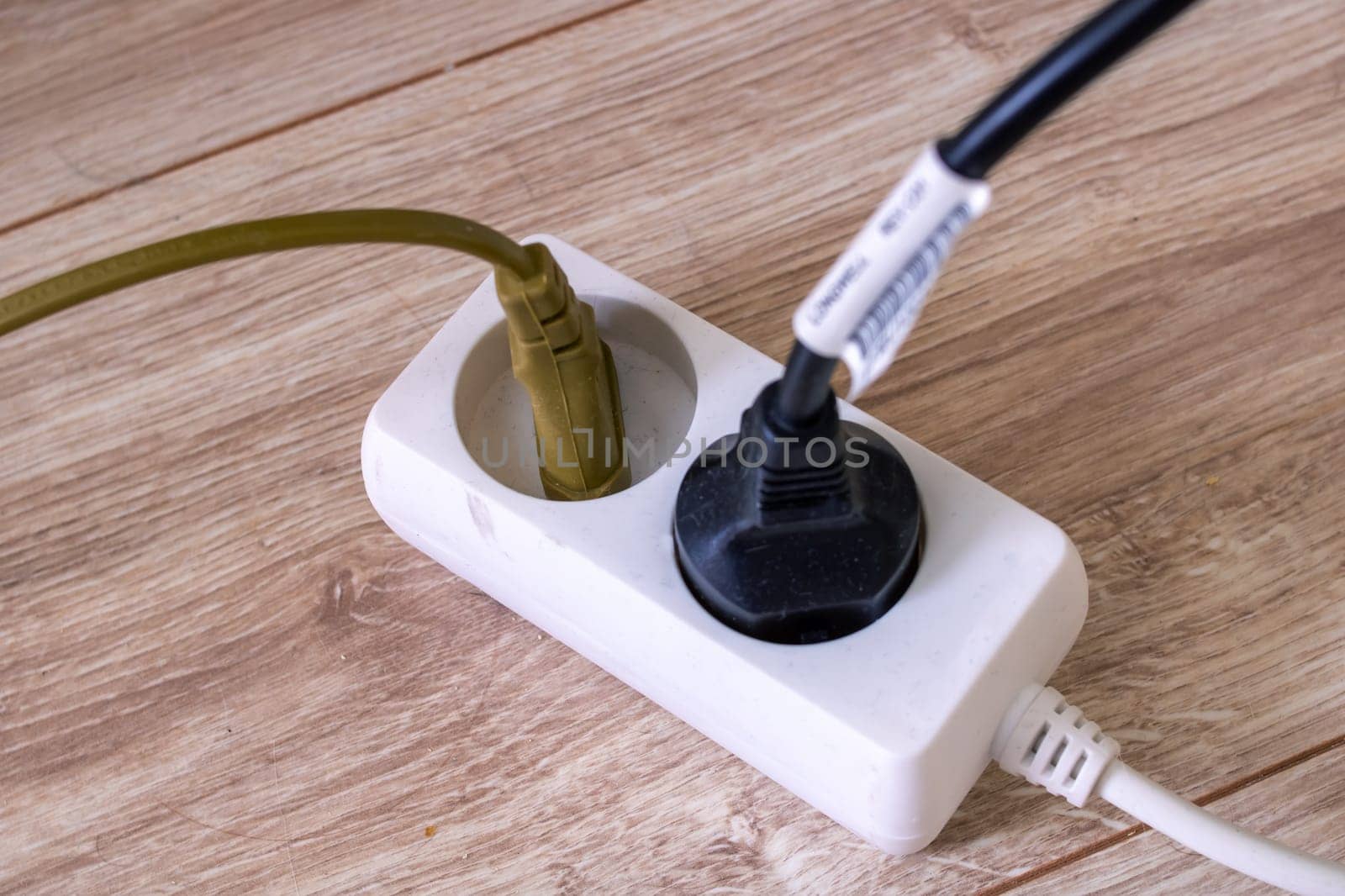 Extension cord with two sockets on the floor close up