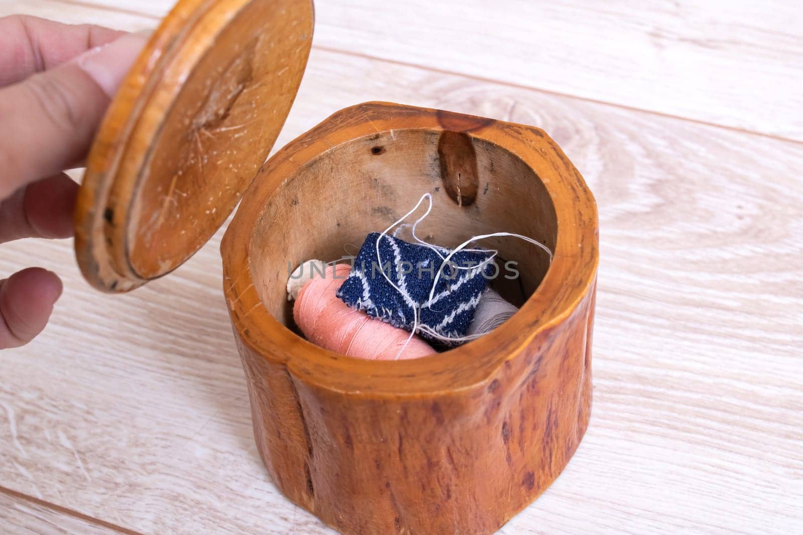 Wooden box with threads and needles close up