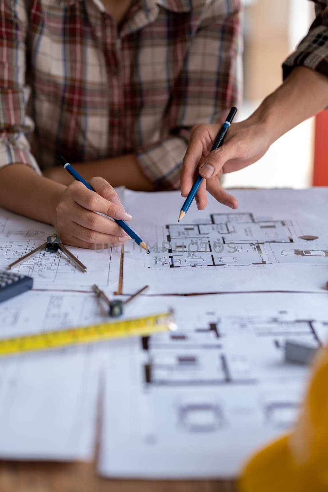 engineer are helping to design work on blueprints, engineer people meeting working and pointing at a paper, professional engineer and architect are drafting a constuction house room building. High quality photo