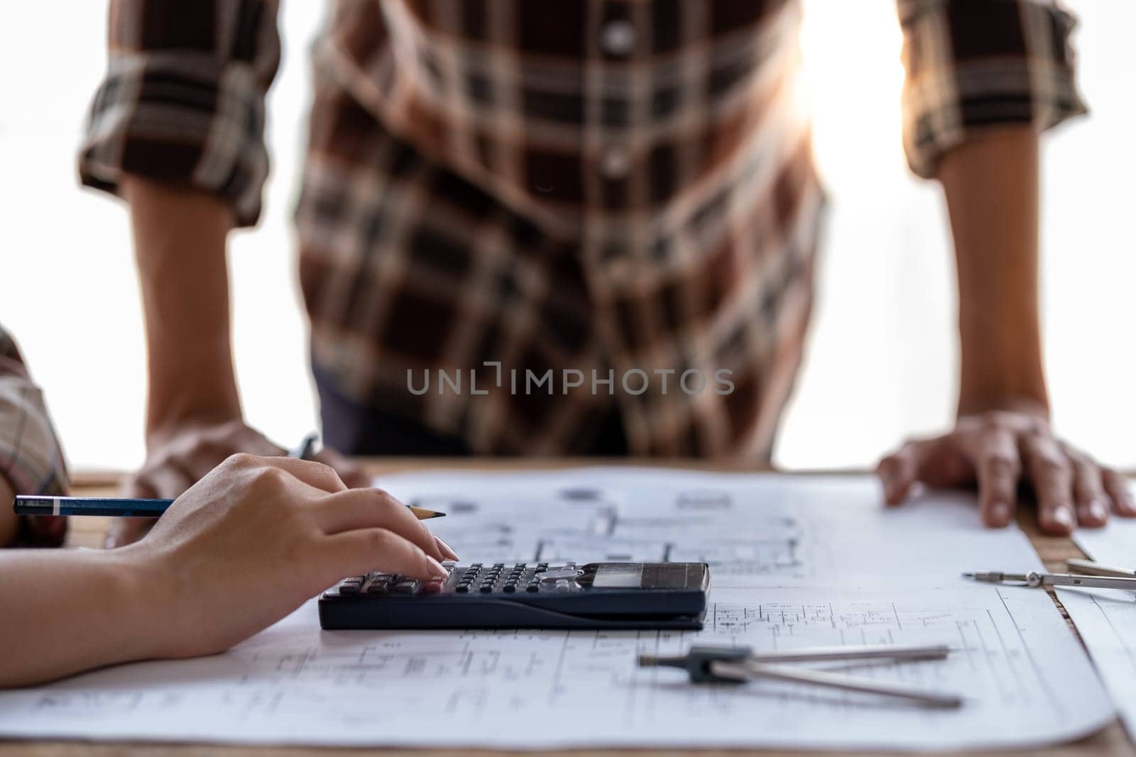 engineer team working in the office, engineer and architect use calculator for calculate drawing design construction, engineer discussion and estimate the cost of project. High quality photo