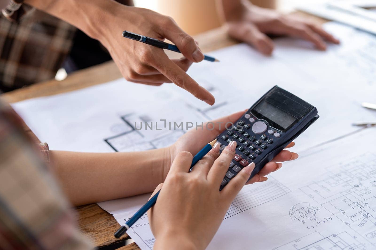 engineer team working in the office, engineer and architect use calculator for calculate drawing design construction by wuttichaicci